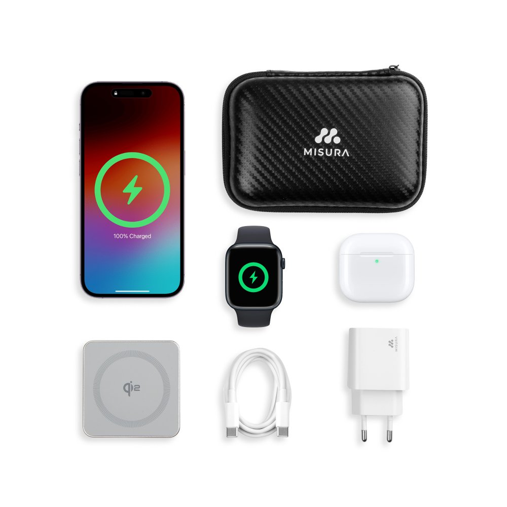 Uno smartphone, uno smartwatch e altri accessori di ricarica sono disposti su una superficie bianca. Il telefono e l'orologio mostrano icone di ricarica.