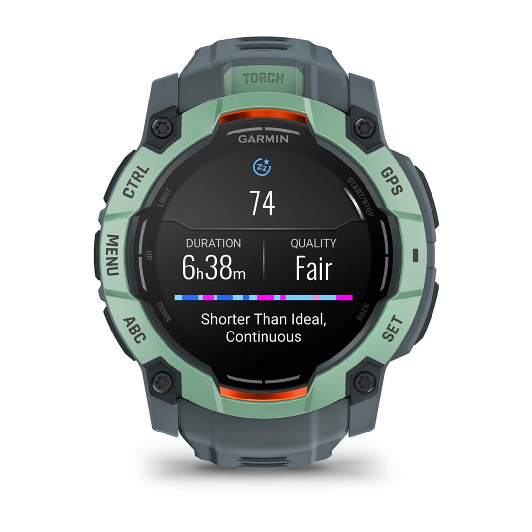 Smartwatch Garmin wyświetla dane dotyczące snu: 74, czas trwania 6h38m, jakość przeciętna. Posiada zielono-szarą obudowę z opisanymi przyciskami.