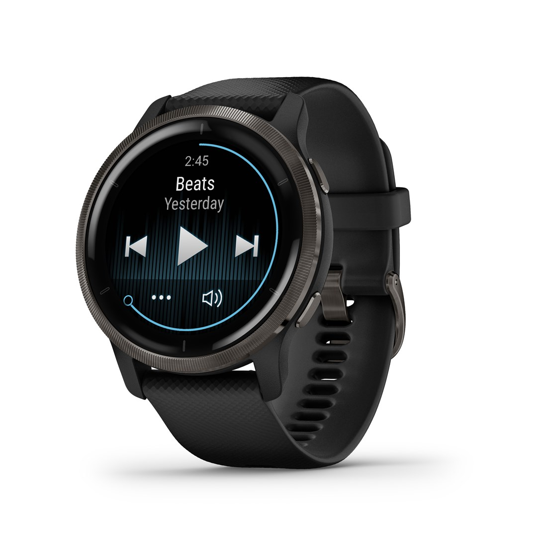 Eine schwarze Garmin-Smartwatch zeigt Musiksteuerungen an. Der Bildschirm zeigt 'Beats Yesterday' an. Die Uhr hat ein schwarzes Band und eine graue Lünette.