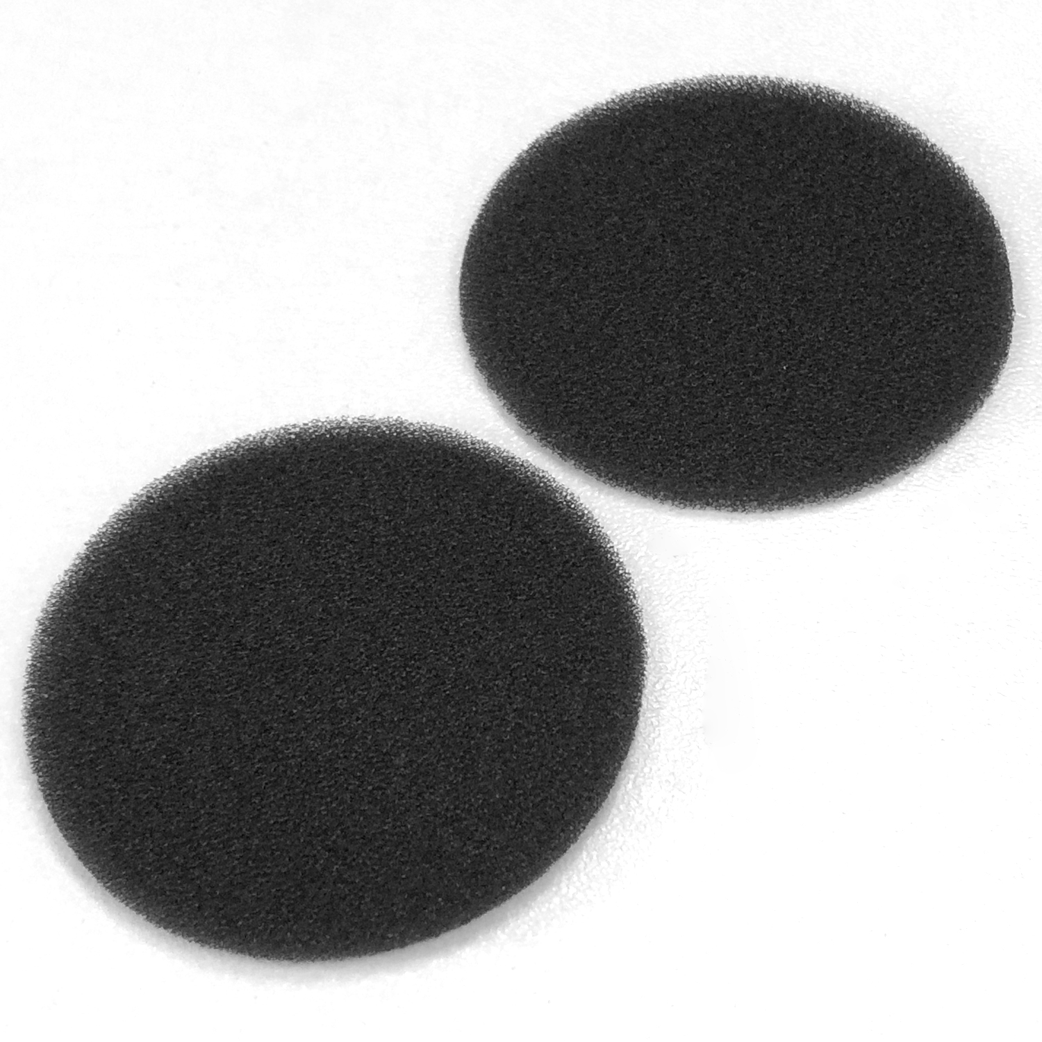 Zwei schwarze, kreisförmige Schaumstoffpads auf einer weißen Oberfläche. Die Pads haben eine strukturierte Oberfläche und sind leicht versetzt.