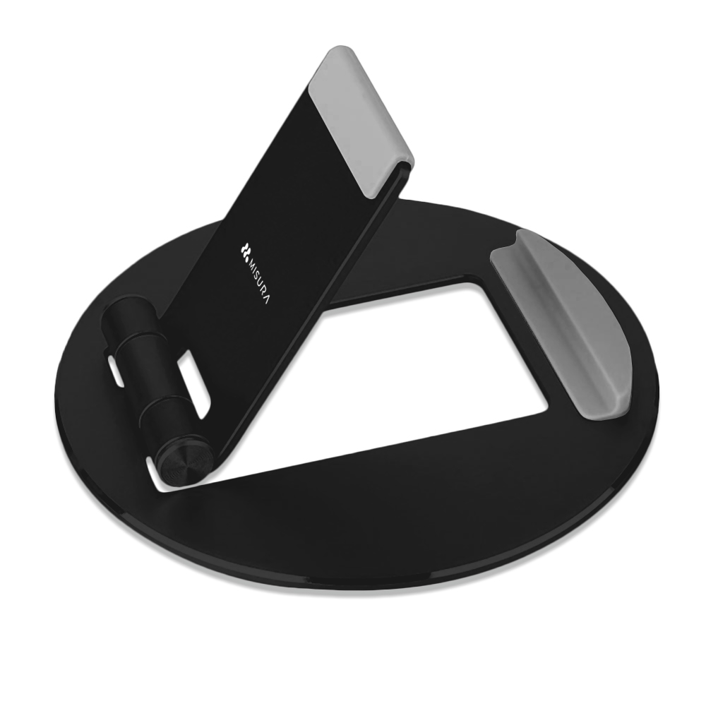 Soporte negro para tablet. Tiene una base circular y un soporte en ángulo con un reposo gris. La marca 'MISURA' es visible.