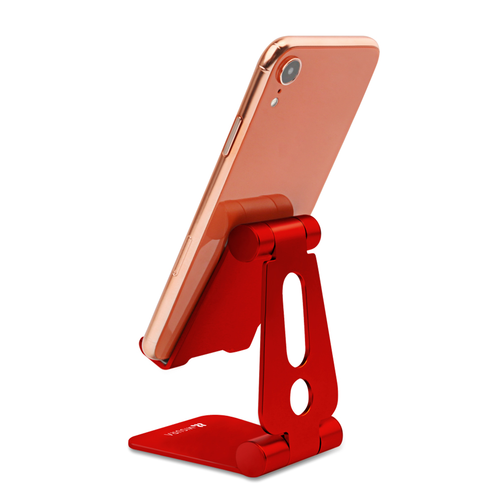 Un telefono oro rosa poggia su un supporto rosso. Il supporto è angolato e il telefono è leggermente inclinato. Lo sfondo è bianco.
