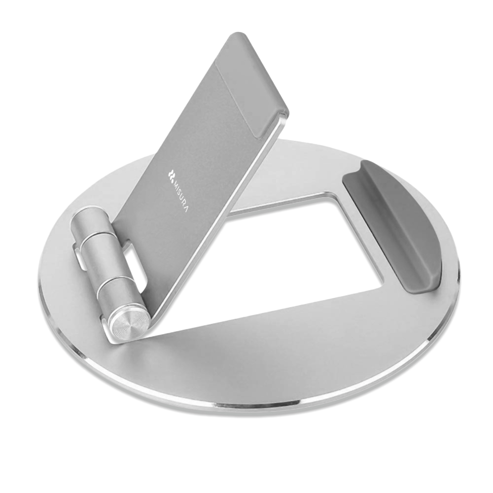 Soporte de teléfono MISURA plateado sobre fondo blanco. Tiene base circular con ranura y brazo articulado para sujetar el teléfono.