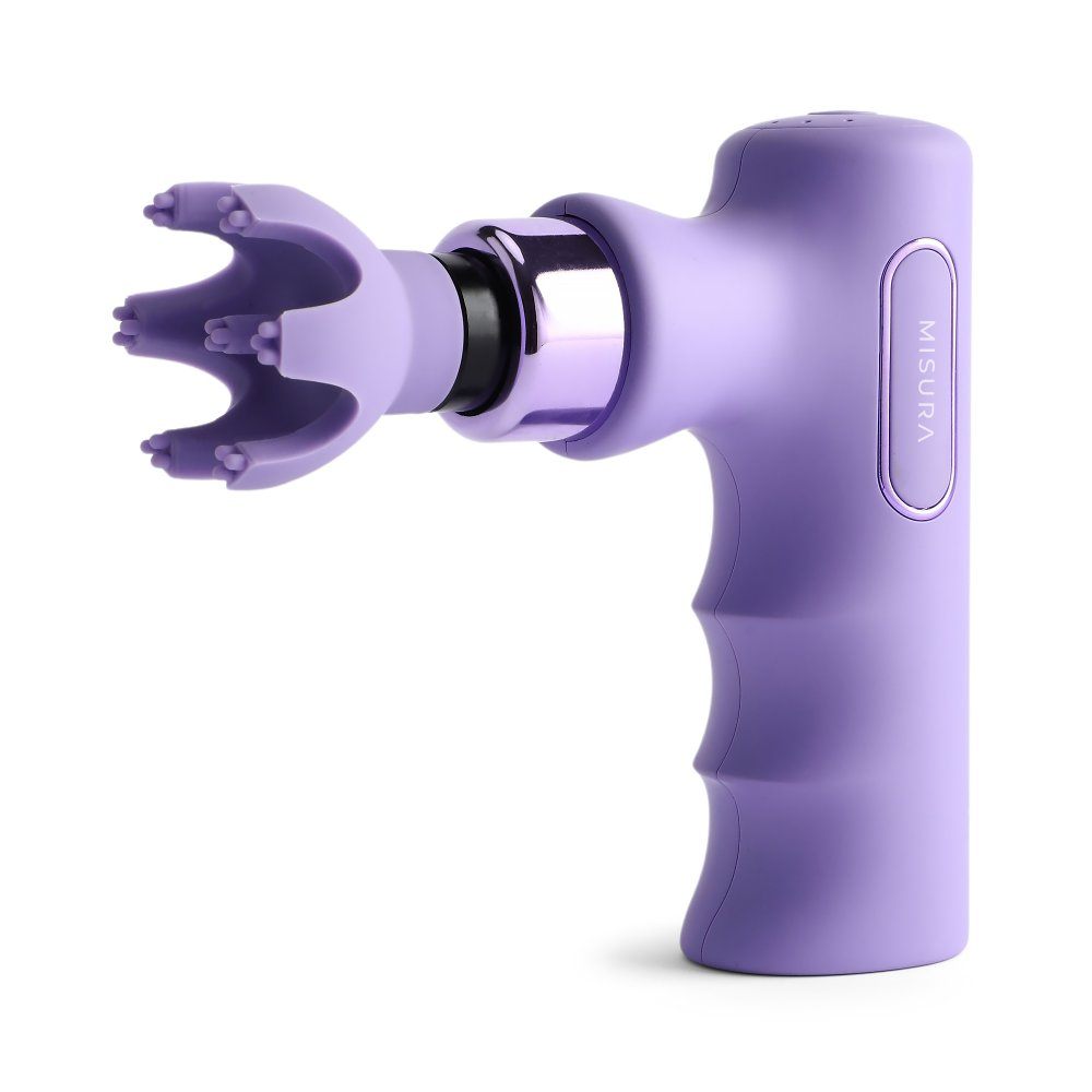 Liliowy pistolet do masażu na białym tle. Ma głowicę w kształcie grzebienia i uchwyt z nadrukiem 'MISURA'.