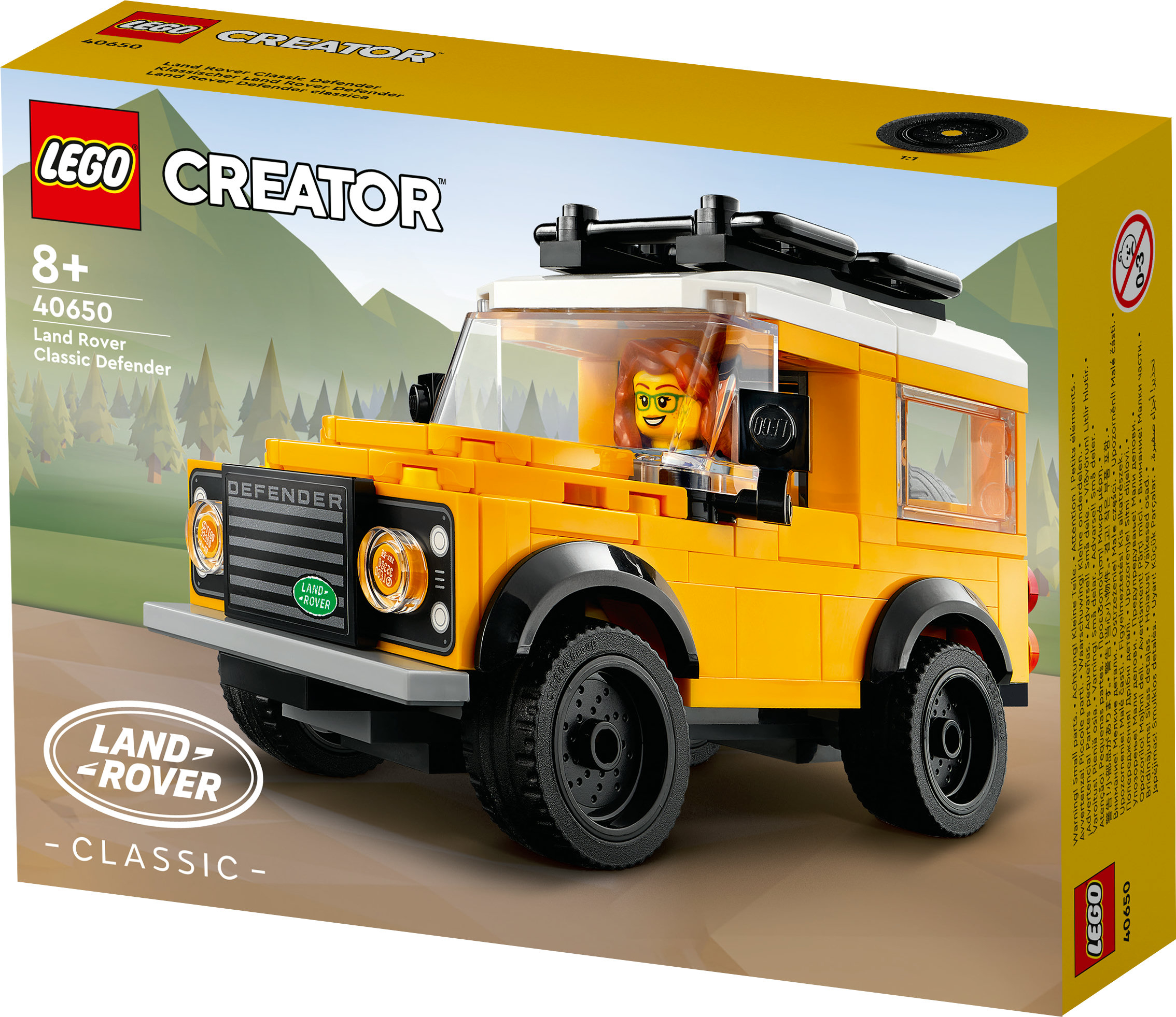 Lego Creator Land Rover Defender kutusu. Siyah tekerlekli sarı araba, kadın sürücü ve yeşil arka plan.