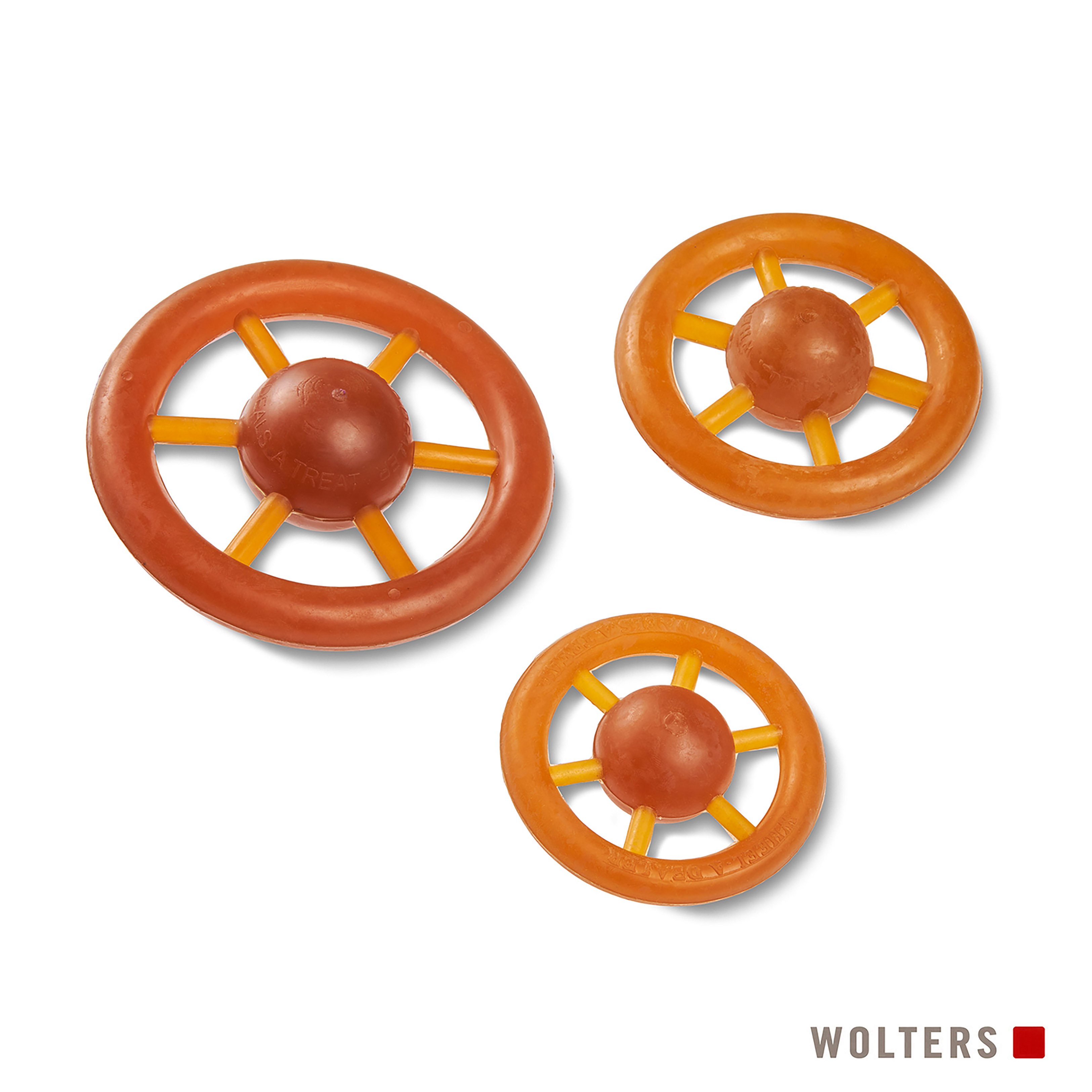Drei orangefarbene Hundespielzeuge in Form von Rädern mit gelben Speichen auf weißem Grund. Der Markenname ist sichtbar.