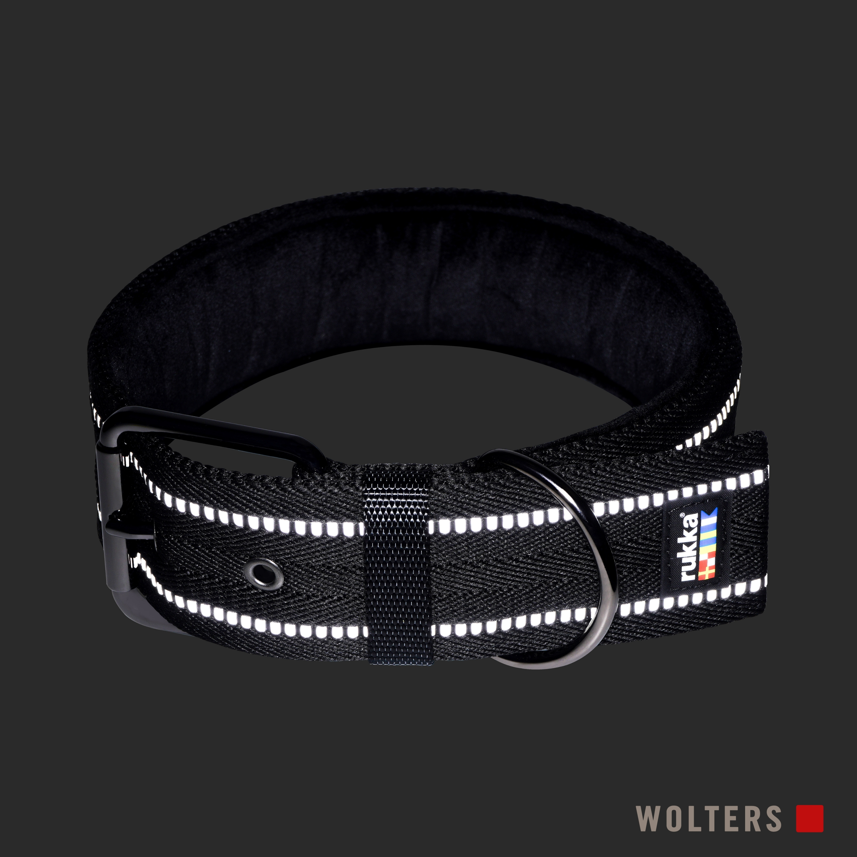 Schwarzes Hundehalsband mit reflektierenden Streifen und einem Metallring. Der Markenname 'rukka' ist sichtbar.