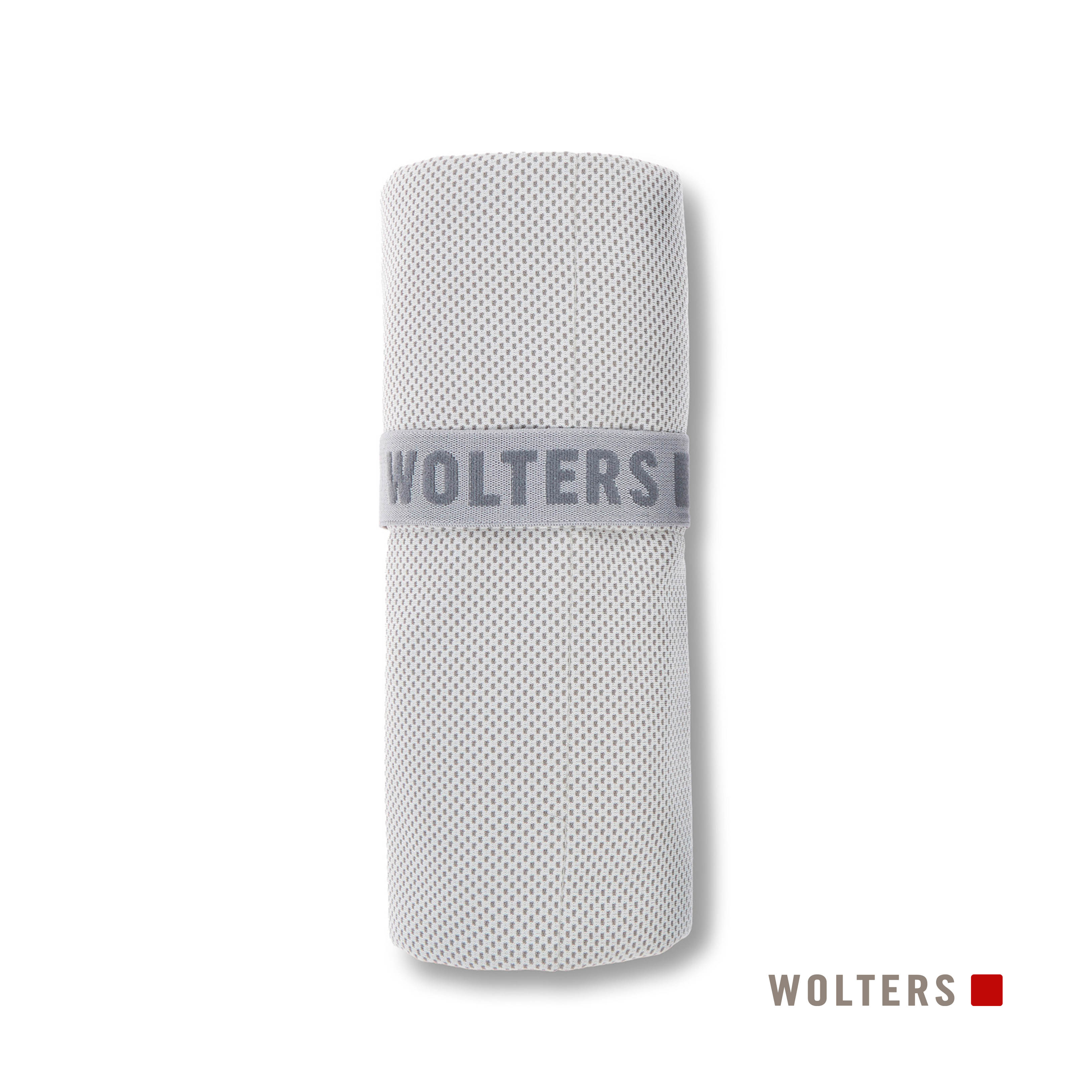Ein gerolltes, hellgraues Handtuch mit einem Band mit der Aufschrift 'WOLTERSI' in Grau. Der Hintergrund ist weiß, mit dem Markenlogo unten.