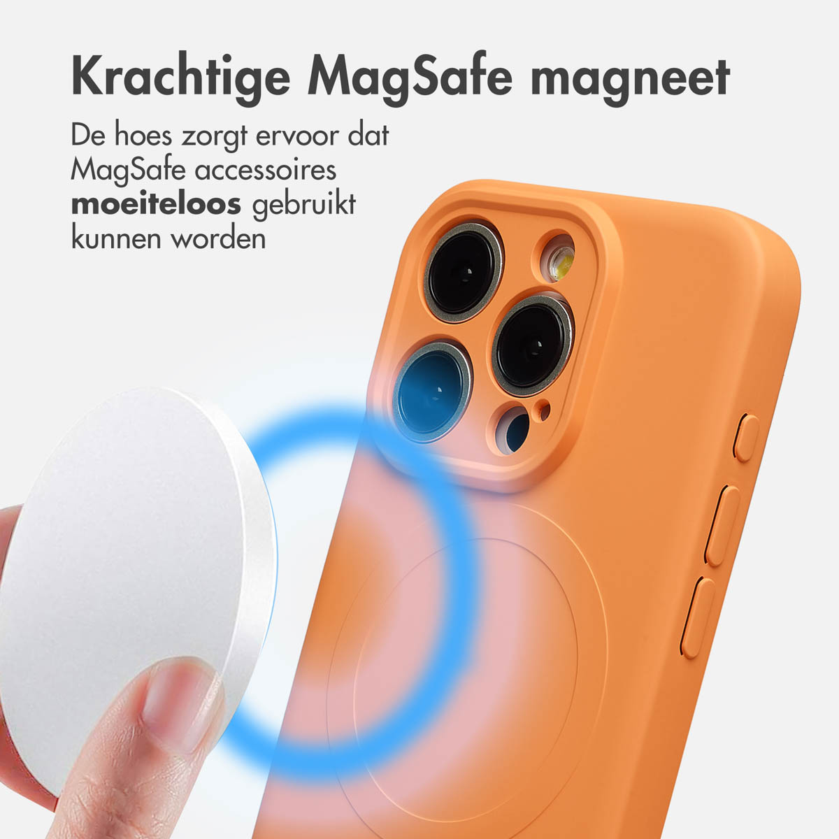 Hand die een witte MagSafe-accessoire vasthoudt in de buurt van een oranje telefoonhoesje, met een blauw magnetisch veldeffect.