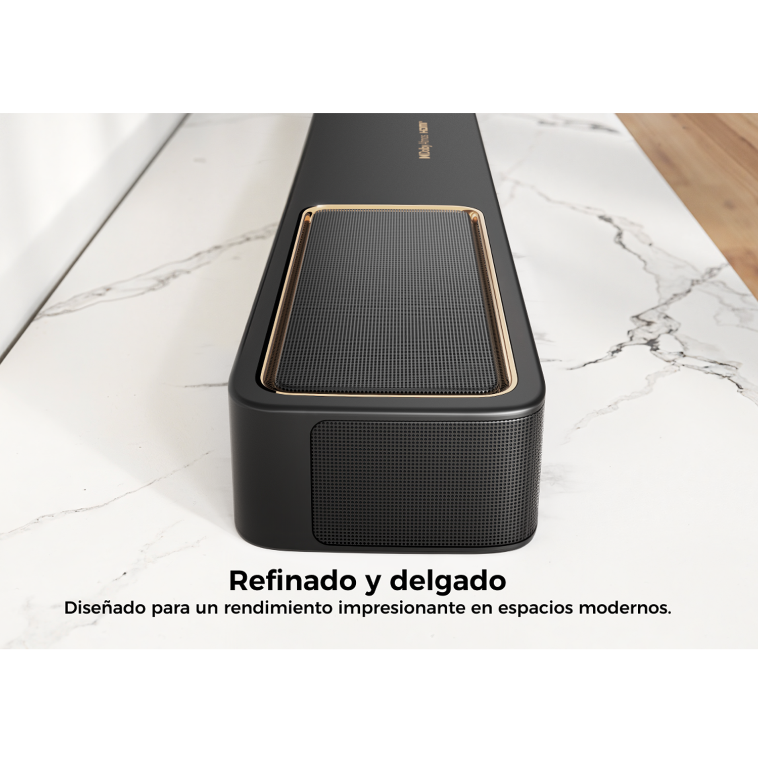 Barra de sonido negra sobre mármol. Ribete dorado, logo Dolby Atmos. Texto: 'Refinado y delgado'.