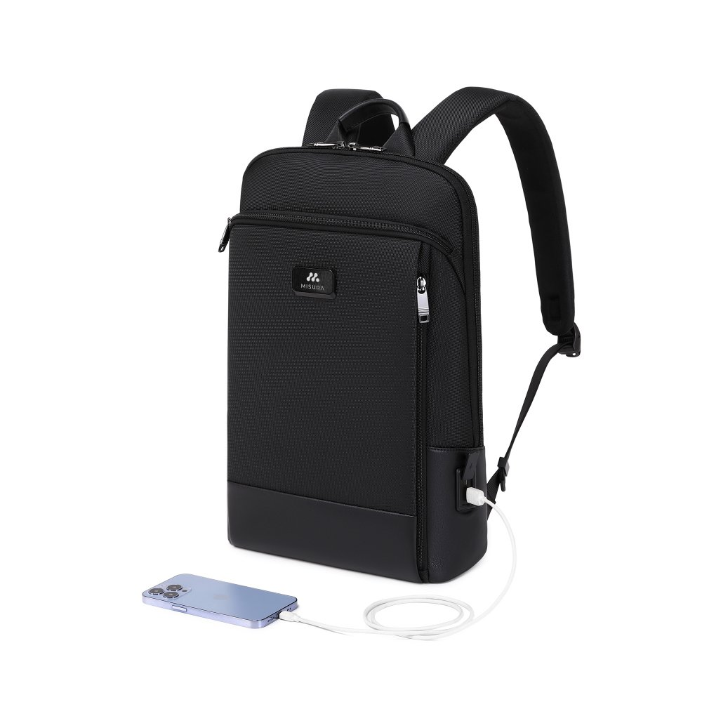 Uno zaino nero con un telefono in carica. Lo zaino ha un design elegante con una tasca frontale e il marchio MISURA.