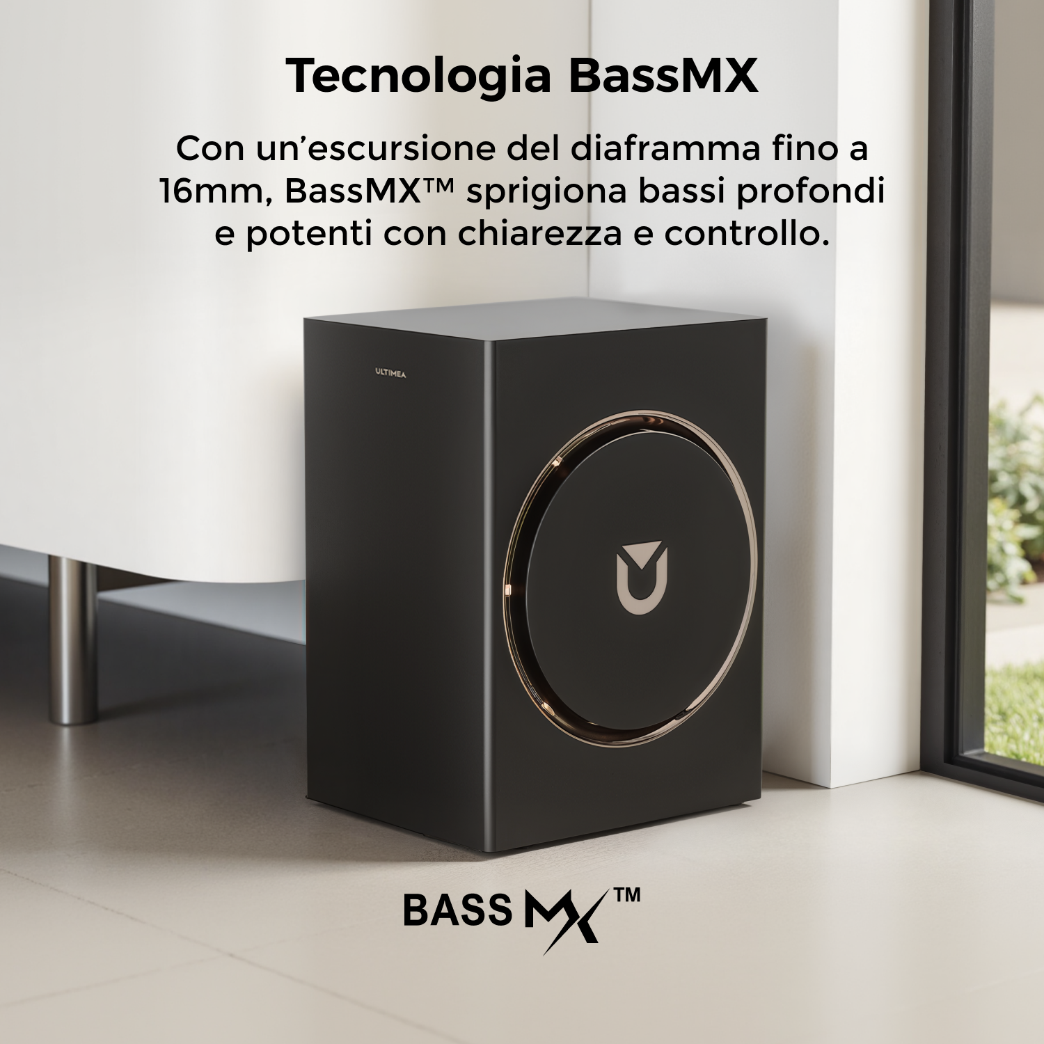 Altoparlante BassMX nero con finiture dorate, posizionato vicino a una finestra. Il testo sull'immagine dice 'BassMX' e ne descrive le funzioni.