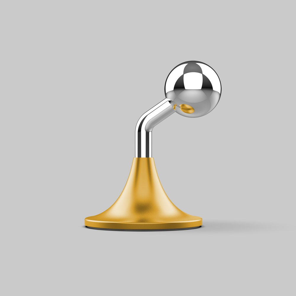 Un accessorio da scrivania dorato e argentato. Ha una base dorata, un braccio argentato e una sfera argentata in cima. Lo sfondo è grigio.