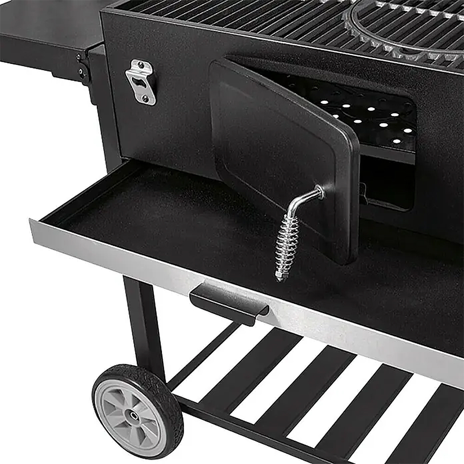 Schwarzer Grill mit offener Tür, die einen Rost, einen Flaschenöffner, eine Ablage und ein Rad zeigt. Der Grill steht auf einem schwarzen Metallrahmen.