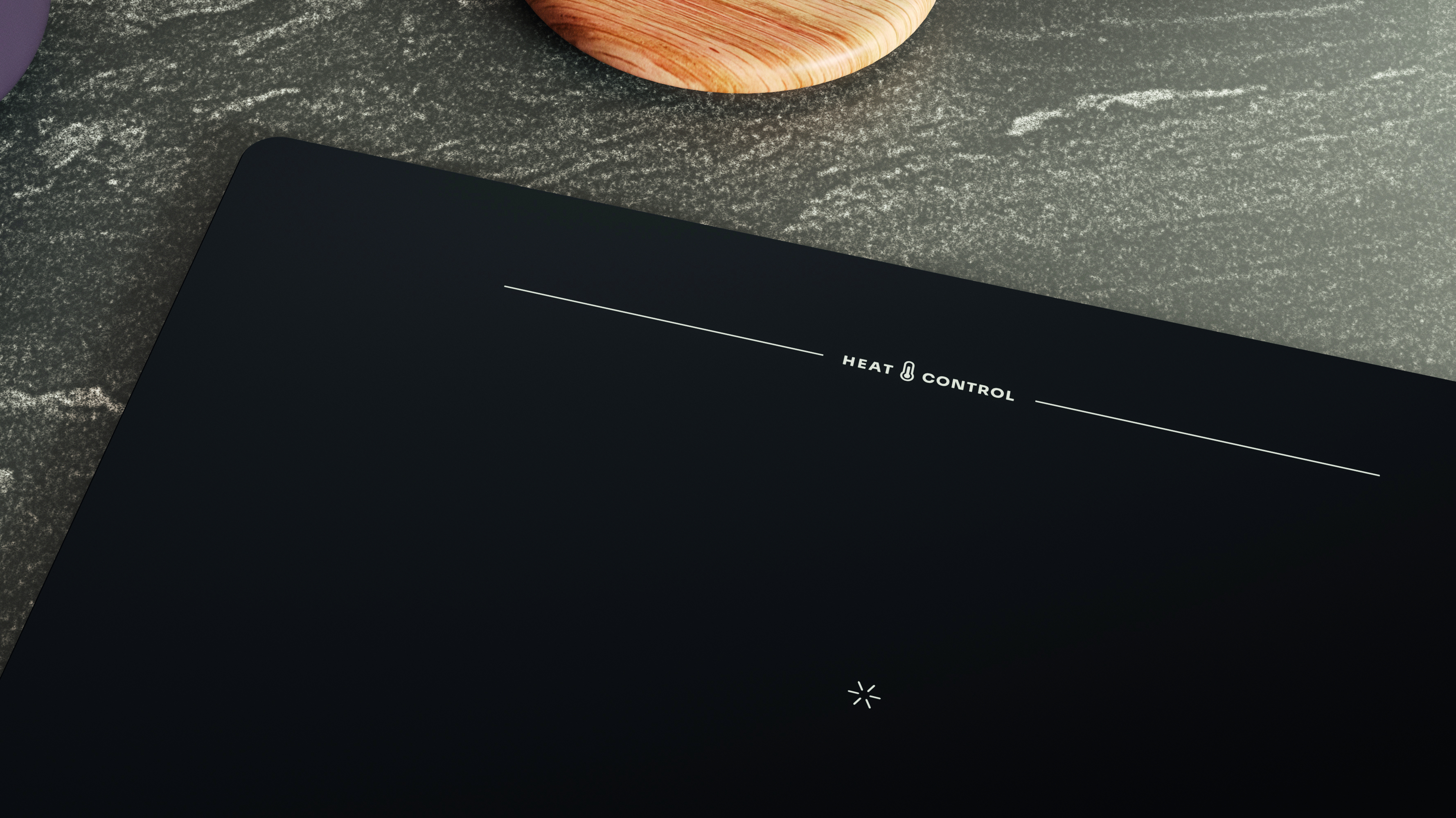 Piano cottura a induzione nero su superficie grigia. Tagliere in legno sullo sfondo. Testo 'HEAT CONTROL' visibile.