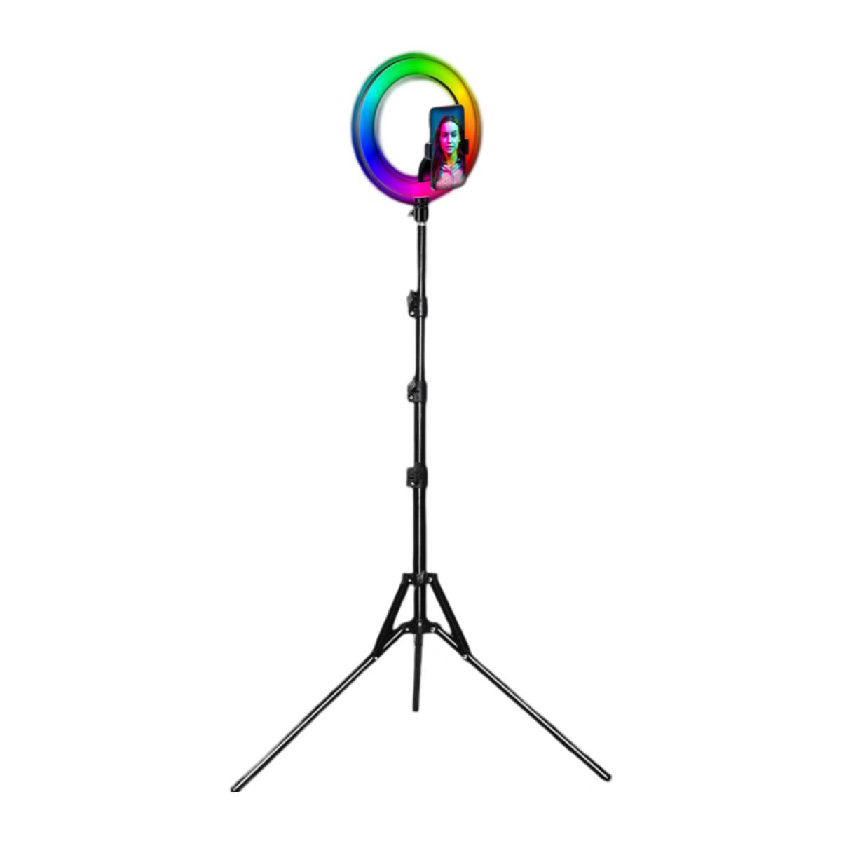 Une lampe annulaire avec un téléphone affichant une femme. La lumière a un dégradé arc-en-ciel. Elle est sur un trépied noir sur fond blanc.