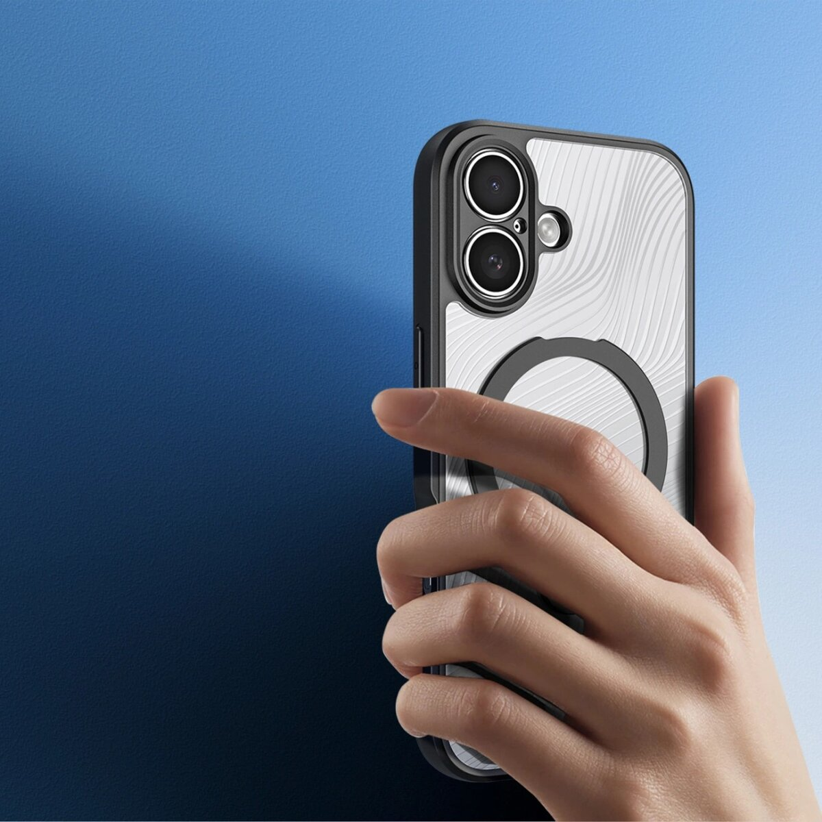 Eine Hand hält ein Telefon mit einer transparenten Hülle. Die Hülle hat einen schwarzen Rand und ein silbernes Design. Der Hintergrund ist blau.