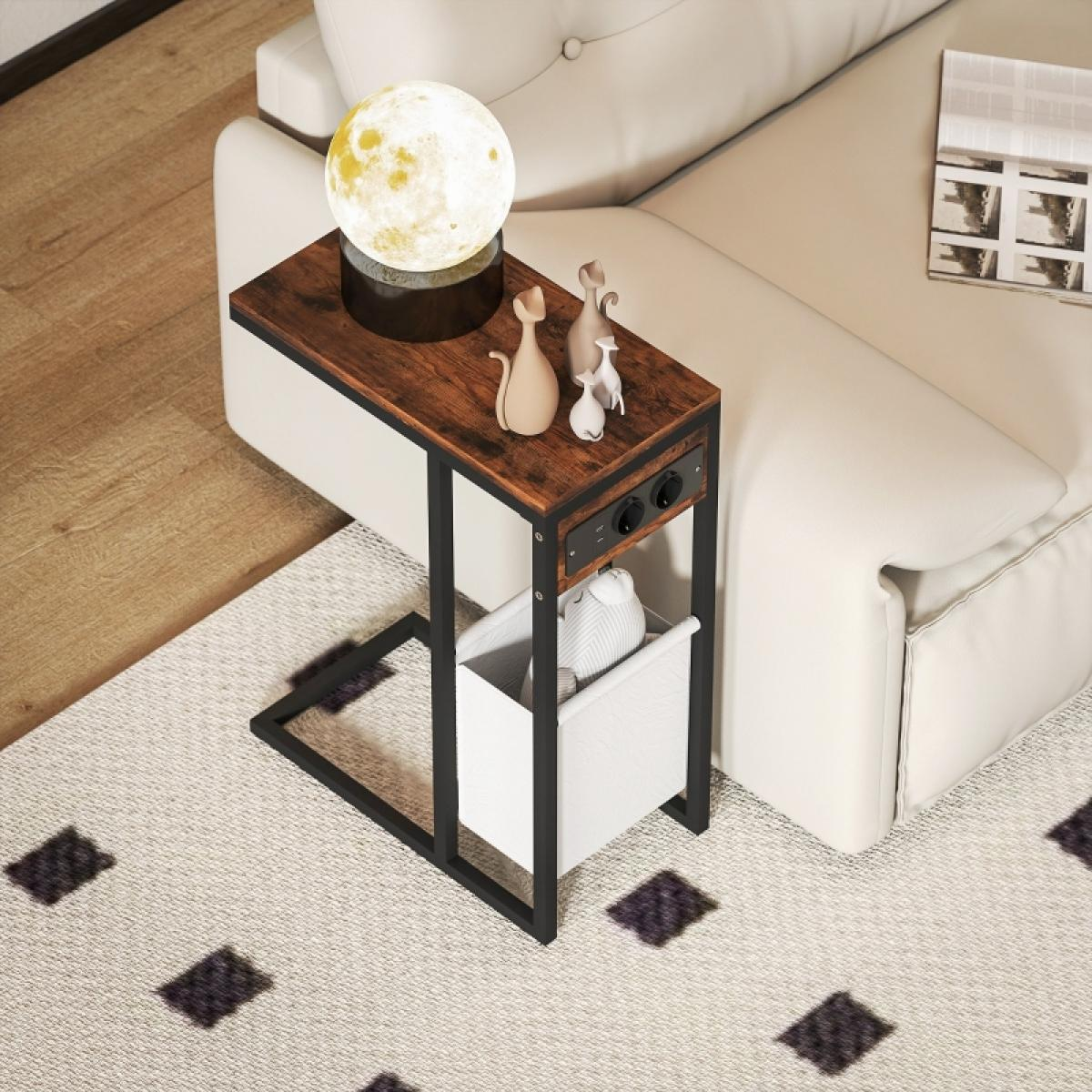 Ein Beistelltisch mit Mondlampe und Katzenfiguren steht neben einem weißen Sofa. Ein weißer Korb enthält Gegenstände auf einem gemusterten Teppich.