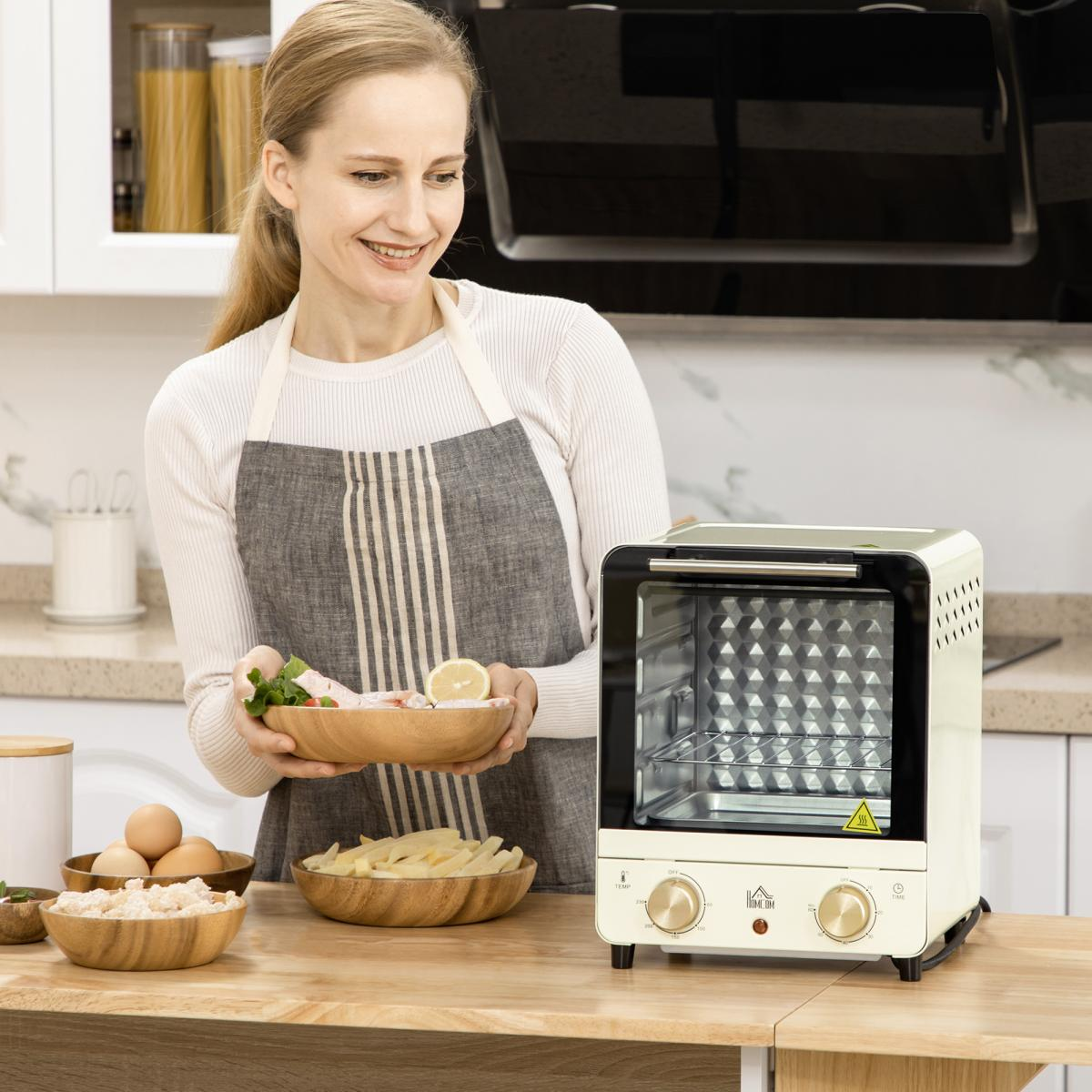 Frau in der Küche mit Schürze, hält eine Schüssel mit Essen. Ofen rechts. Schalen mit Essen und Eiern auf dem Tisch.
