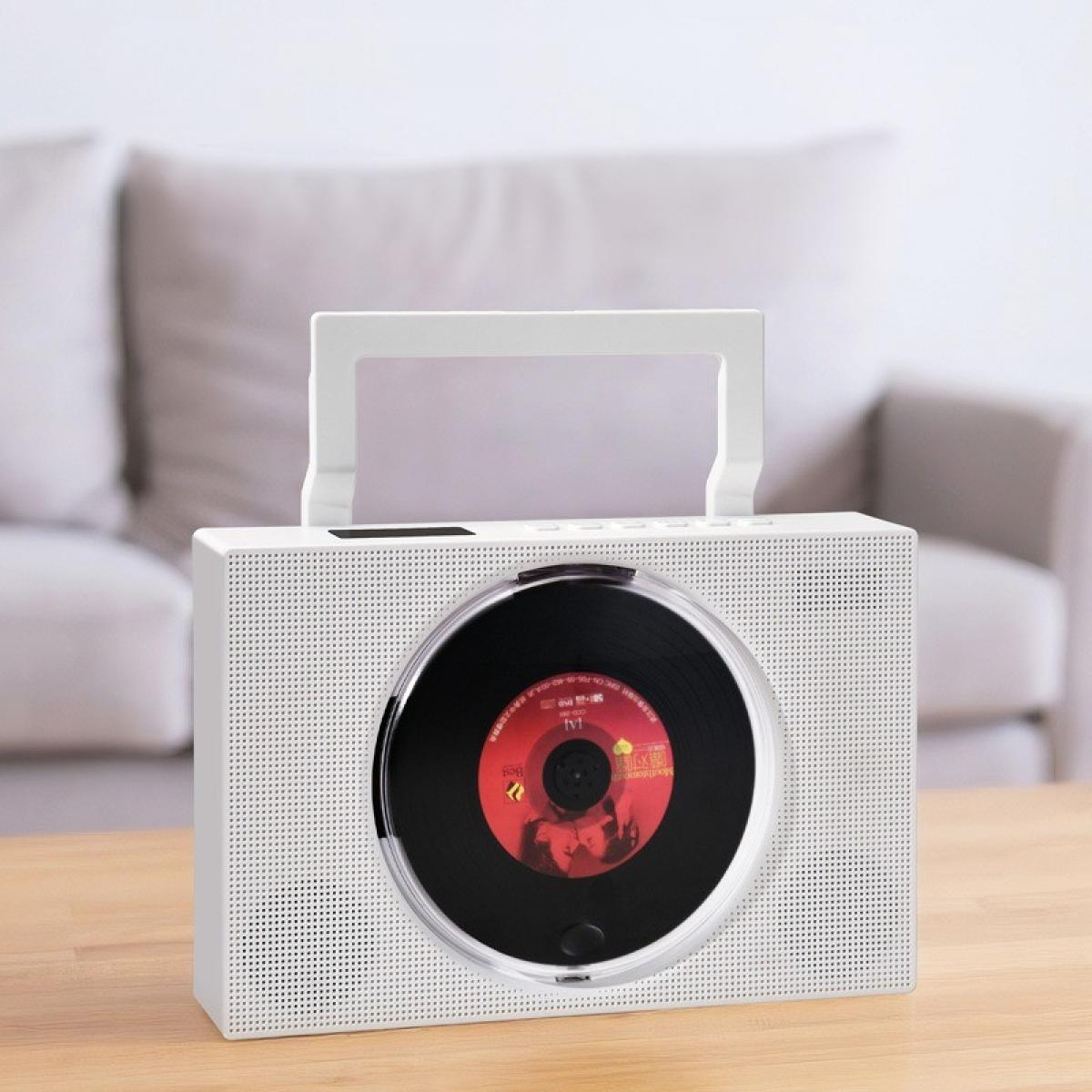 Ein weißer CD-Player mit einer CD im Inneren steht auf einem Holztisch. Im Hintergrund ist ein Sofa zu sehen.