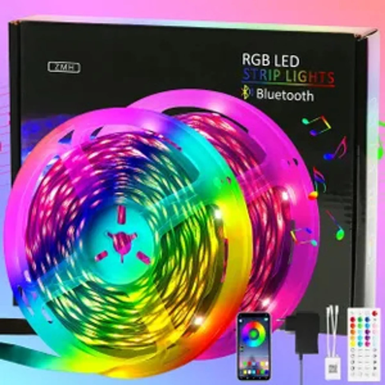 RGB-LED-Streifenlichter in bunten Rollen, mit Smartphone, Fernbedienung und Netzteil, auf einer schwarzen Box.