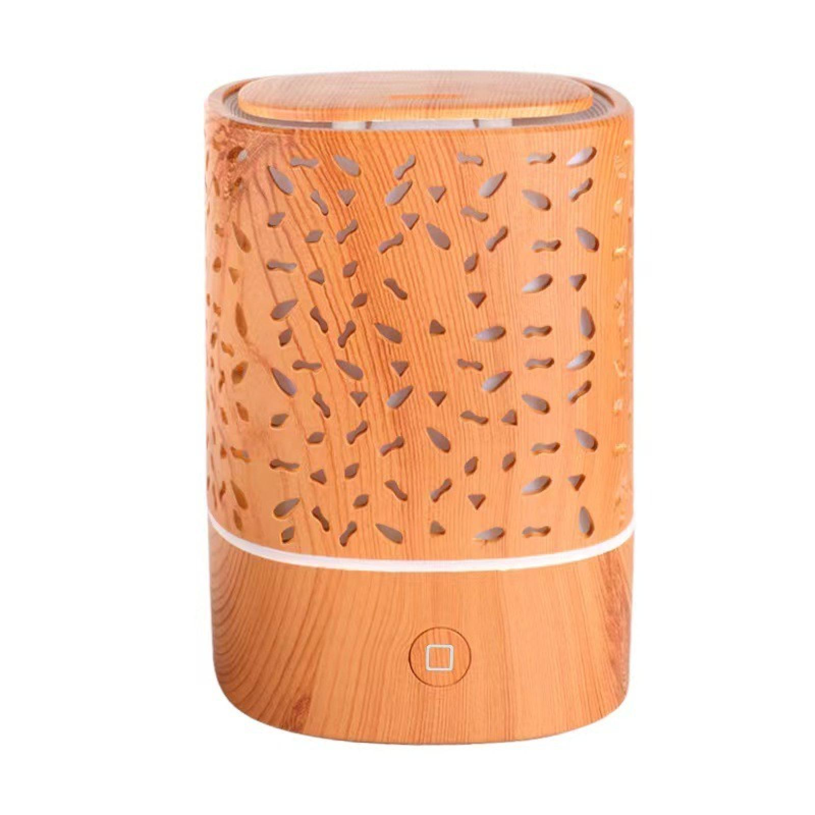 Ein Aroma-Diffusor aus Holz mit ausgeschnittenen Mustern. Er hat einen Knopf und ist zylindrisch mit flacher Oberseite.