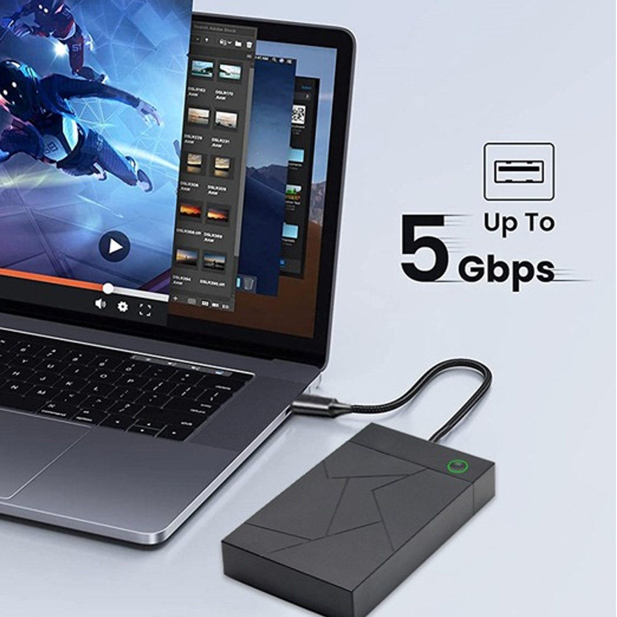 Laptop mit schwarzer externer Festplatte verbunden. Auf dem Bildschirm wird ein Video abgespielt. Text zeigt 5 Gbit/s Übertragungsgeschwindigkeit.