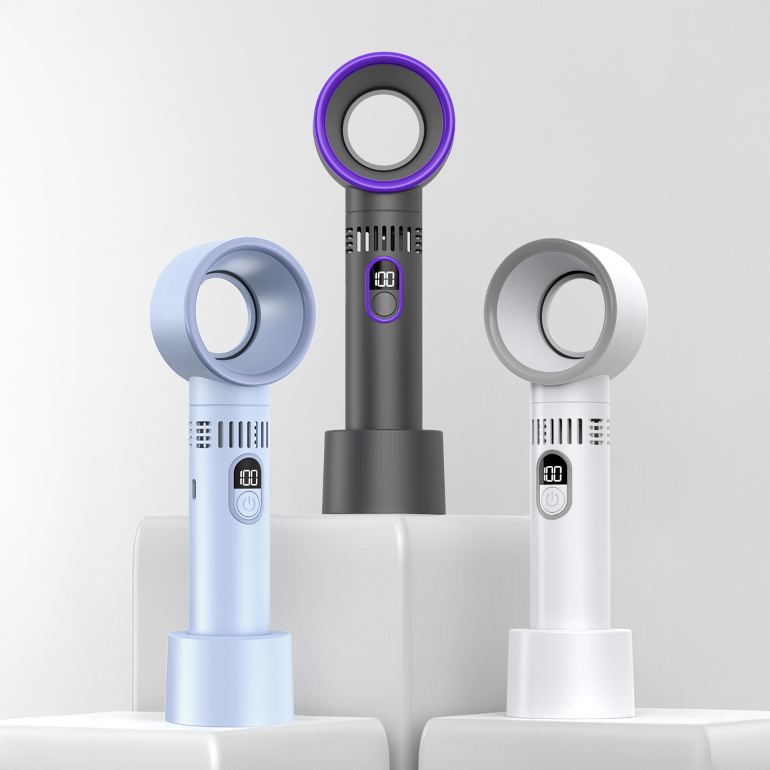 Tre ventilatori senza pale in diversi colori: azzurro chiaro, nero con viola e bianco. Ognuno ha un display digitale e una base rotonda.