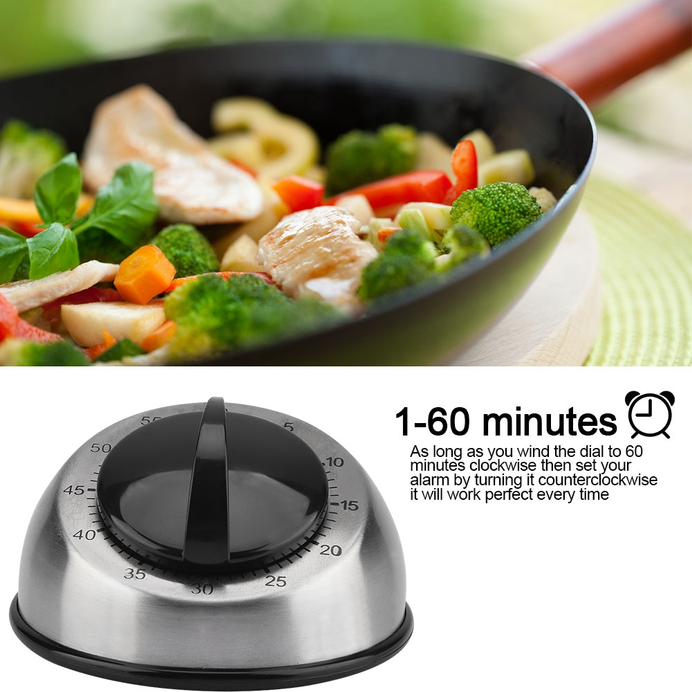 Im Vordergrund ein Timer mit schwarzem Zifferblatt. Im Hintergrund eine Pfanne mit Gemüse und Hühnchen.