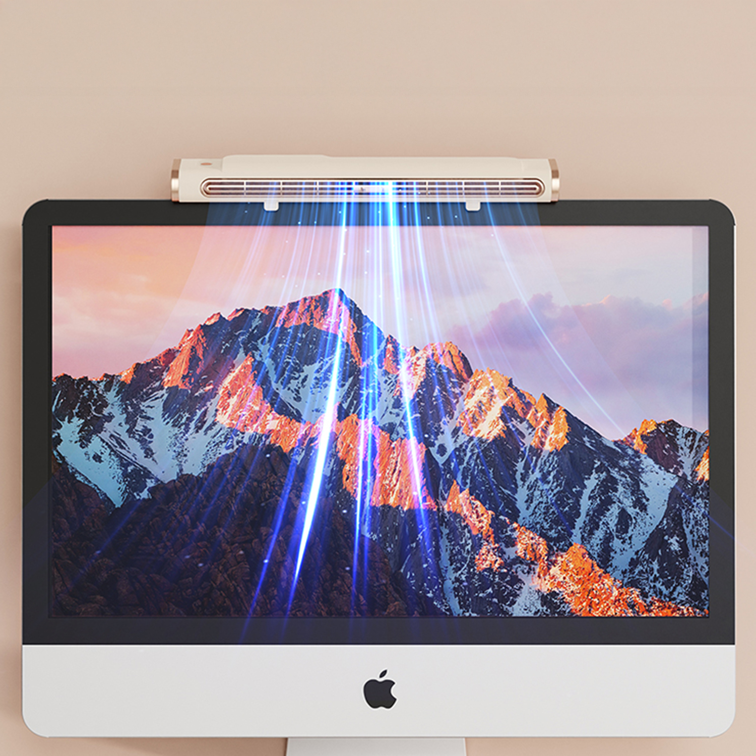 Un monitor con una scena di montagna. Sopra, una luce emette raggi blu. Il monitor ha una base bianca e il logo Apple.