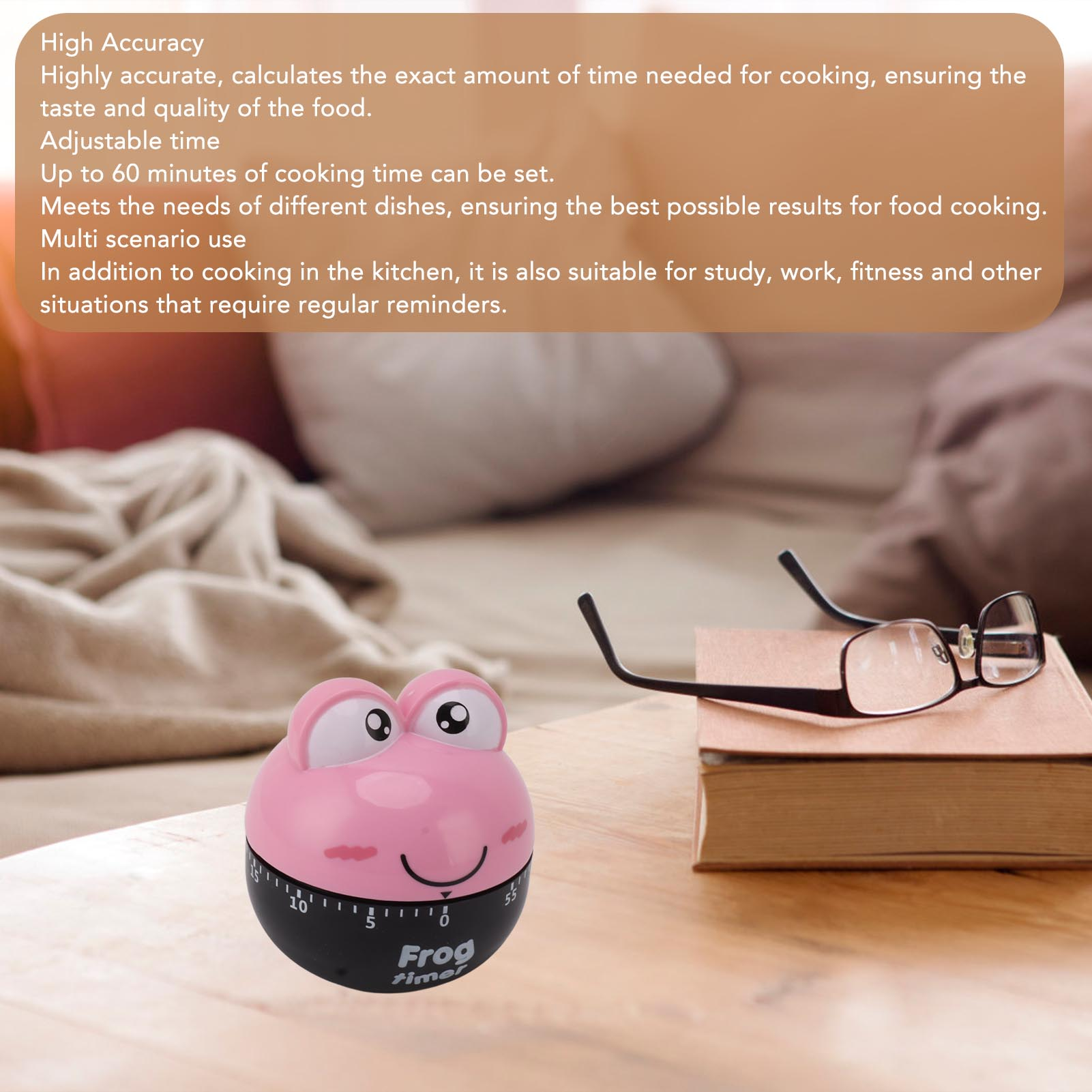 Ein rosa Frosch-Timer und eine Brille auf einem Buch. Der Timer hat einen schwarzen Sockel.