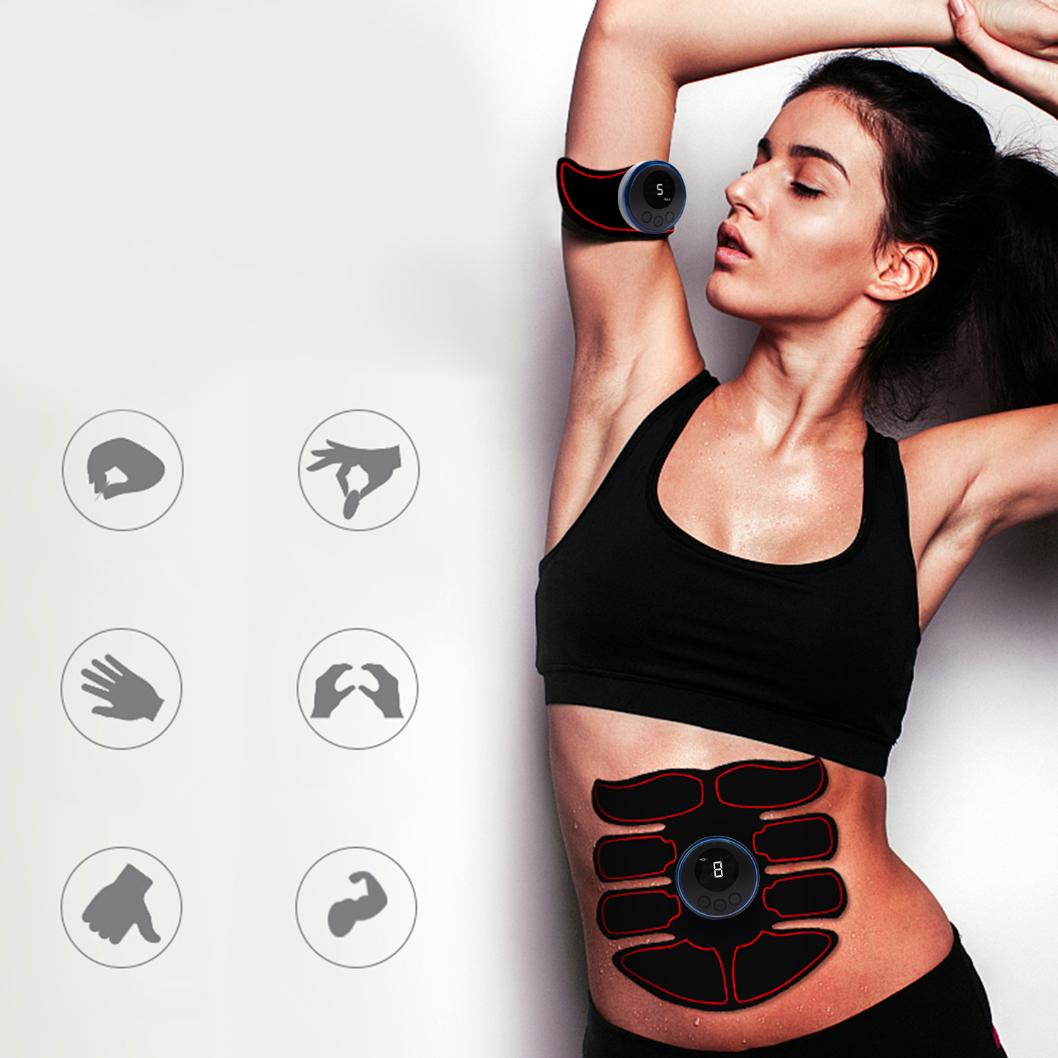 Una mujer con sujetador deportivo y pantalones cortos negros, usando un estimulador muscular abdominal. El dispositivo está en su brazo y abdomen.