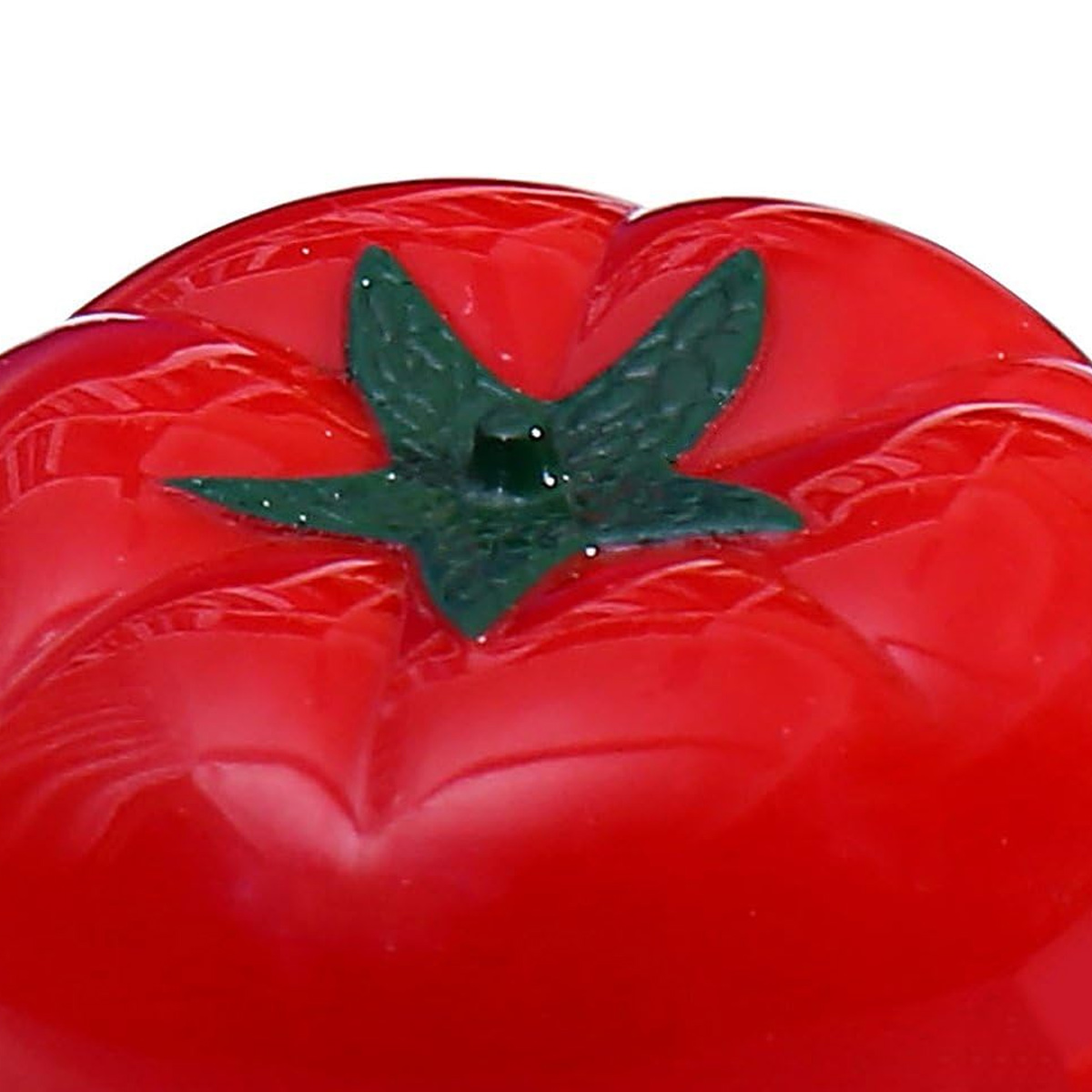 Nahaufnahme einer glänzenden roten Tomate mit grünem sternförmigen Oberteil. Der Hintergrund ist weiß und hebt Farbe und Textur hervor.