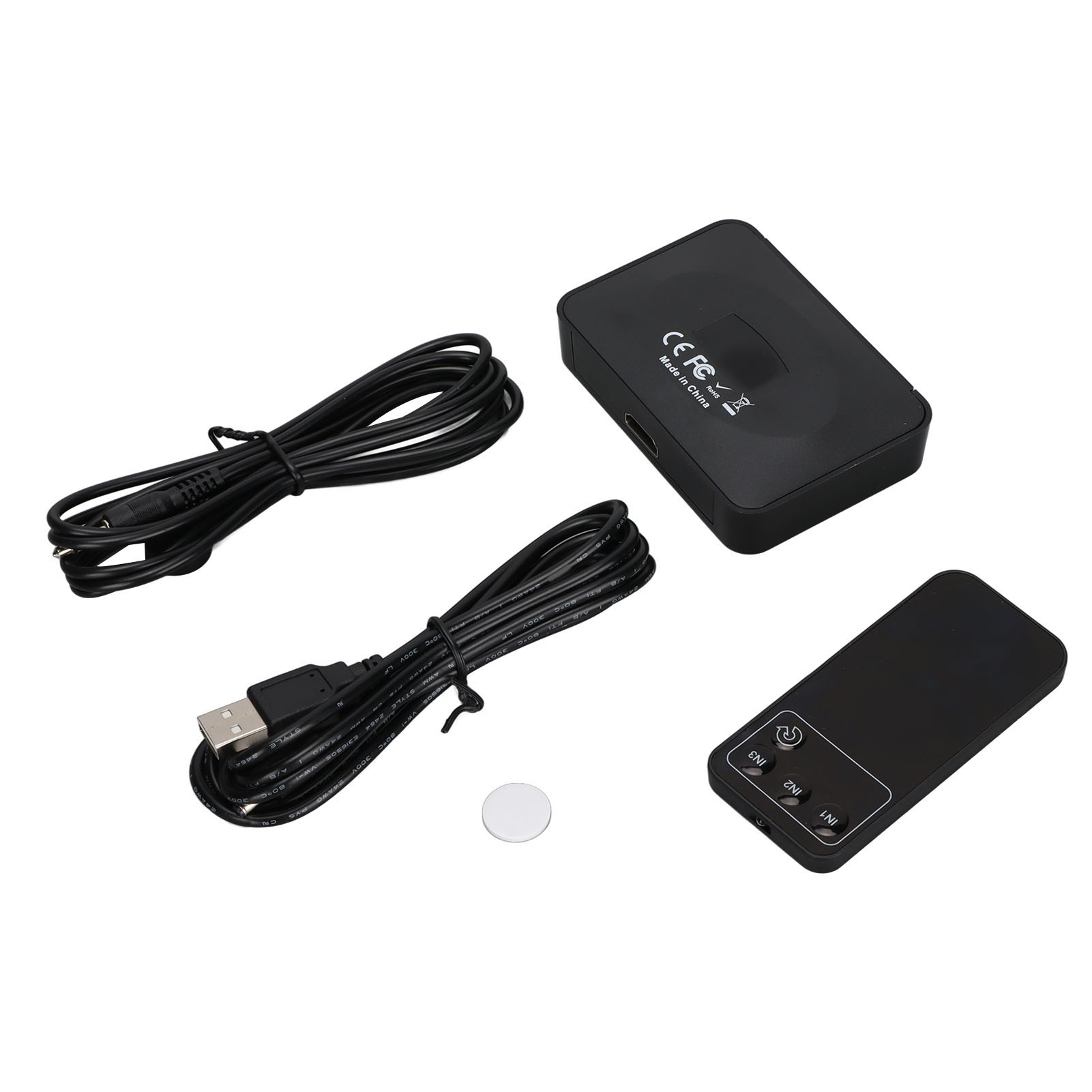 Schwarze elektronische Geräte und Kabel auf weißem Hintergrund. Enthält Fernbedienung, Empfänger und Verbindungskabel.
