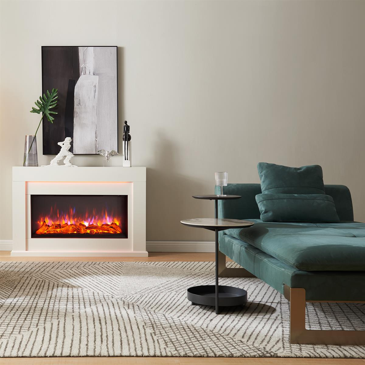 Ein Wohnzimmer mit Kamin, teal Sofa und gemustertem Teppich. Über dem Kamin hängt ein Gemälde.