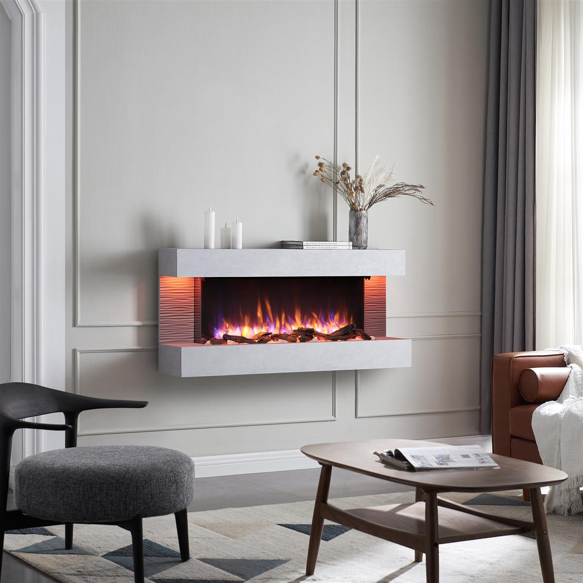 Moderner Kamin mit Flammen, Kerzen und Trockenblumen. Ein grauer Stuhl und ein Couchtisch sind im Vordergrund.