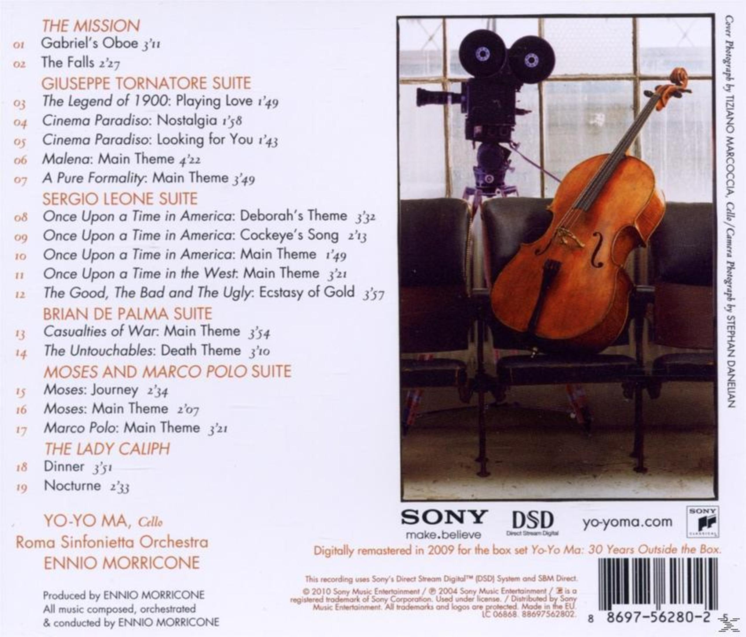 Ein Cello steht neben einer alten Filmkamera auf einem Stuhl. Im Hintergrund ist ein Fenster zu sehen.