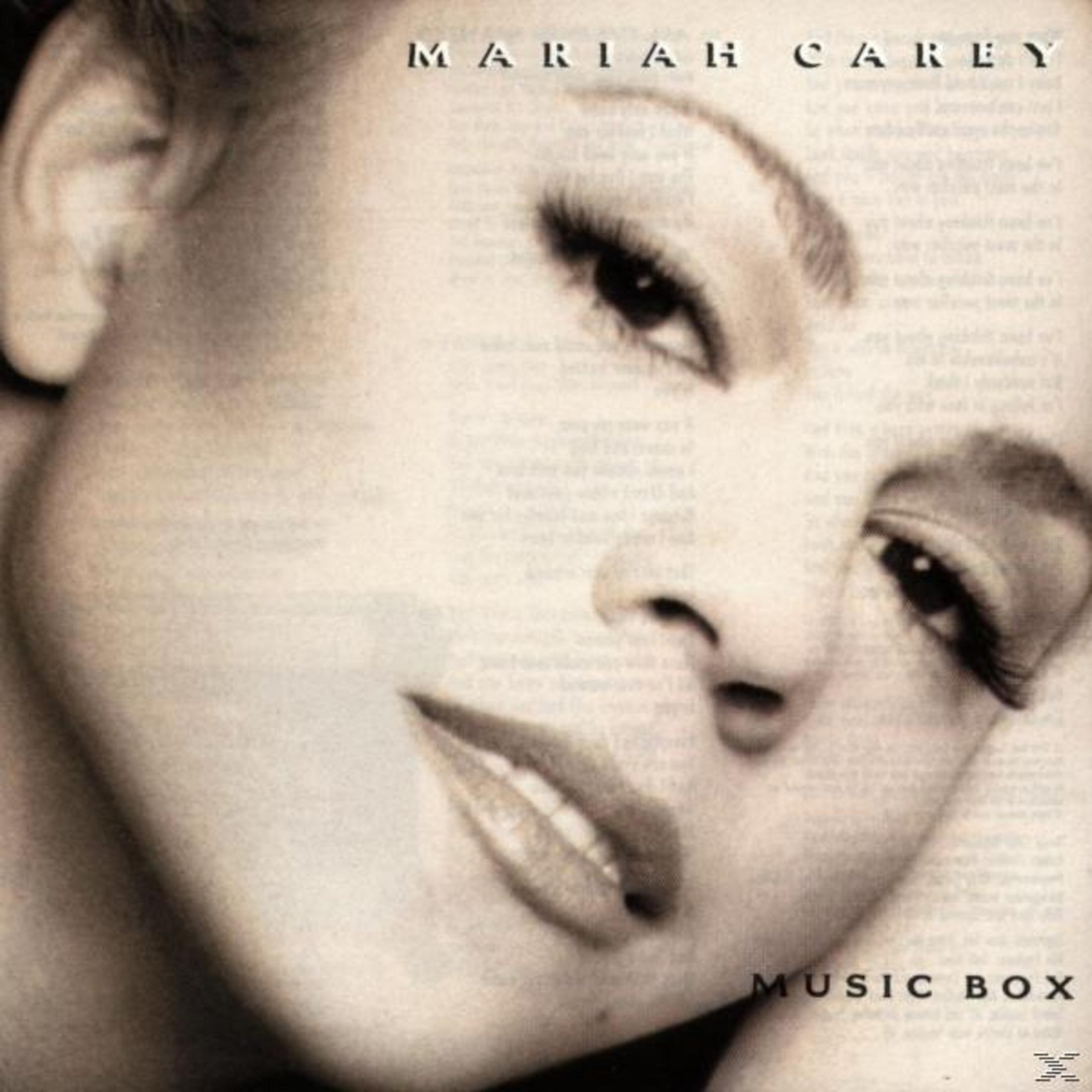 Copertina dell'album di Mariah Carey. Primo piano del suo volto con il titolo 'Music Box'. Illuminazione soffusa e toni seppia.