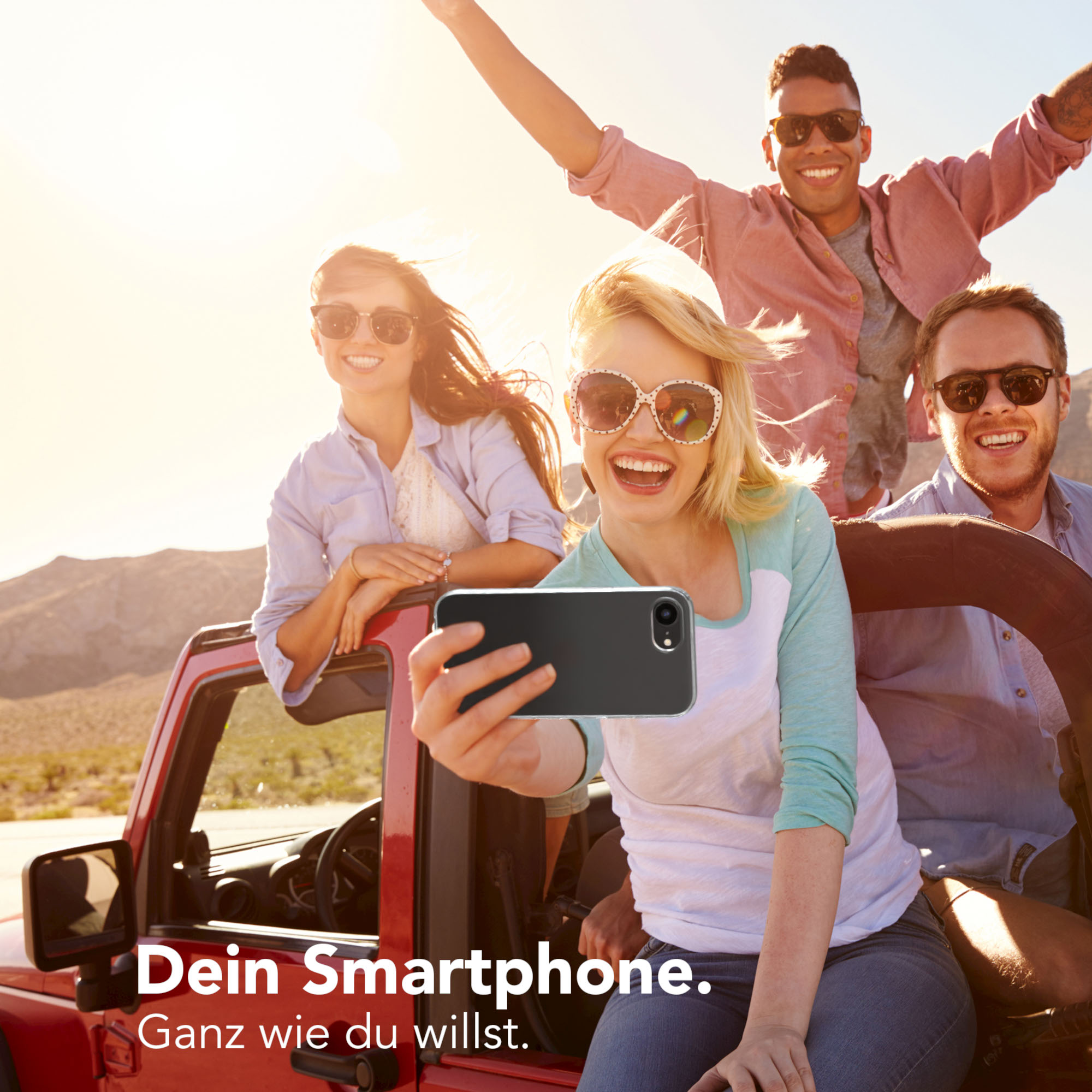 Vier Freunde in einem roten Auto machen ein Selfie. Einer hält das Telefon. Text: Dein Smartphone. Ganz wie du willst.