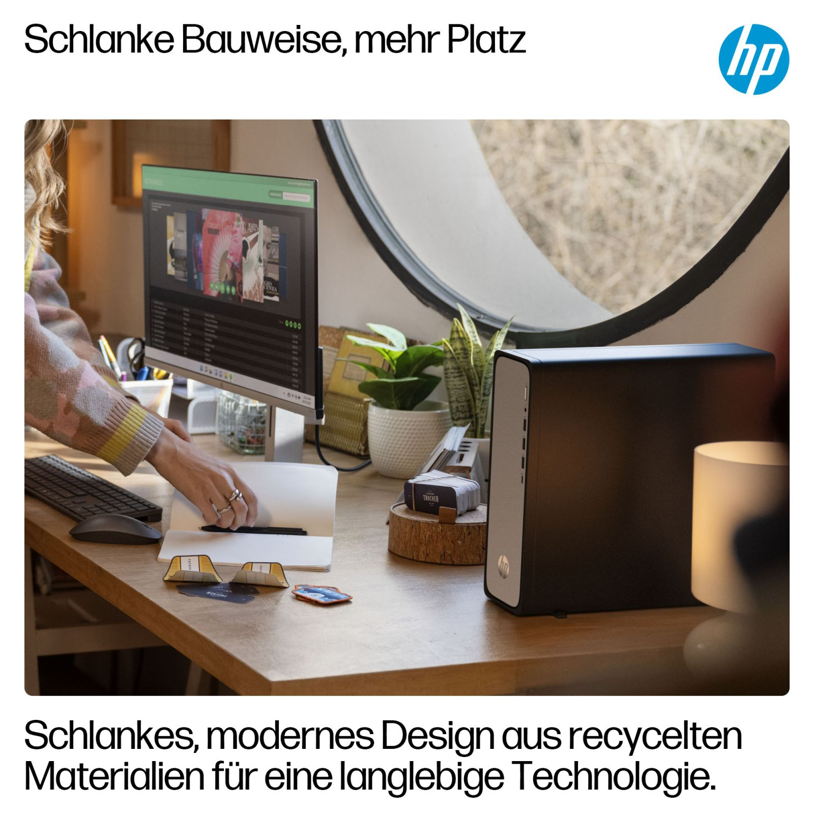 Biurko z komputerem, czarnym komputerem i rękami osoby. Na biurku są rośliny i lampa.