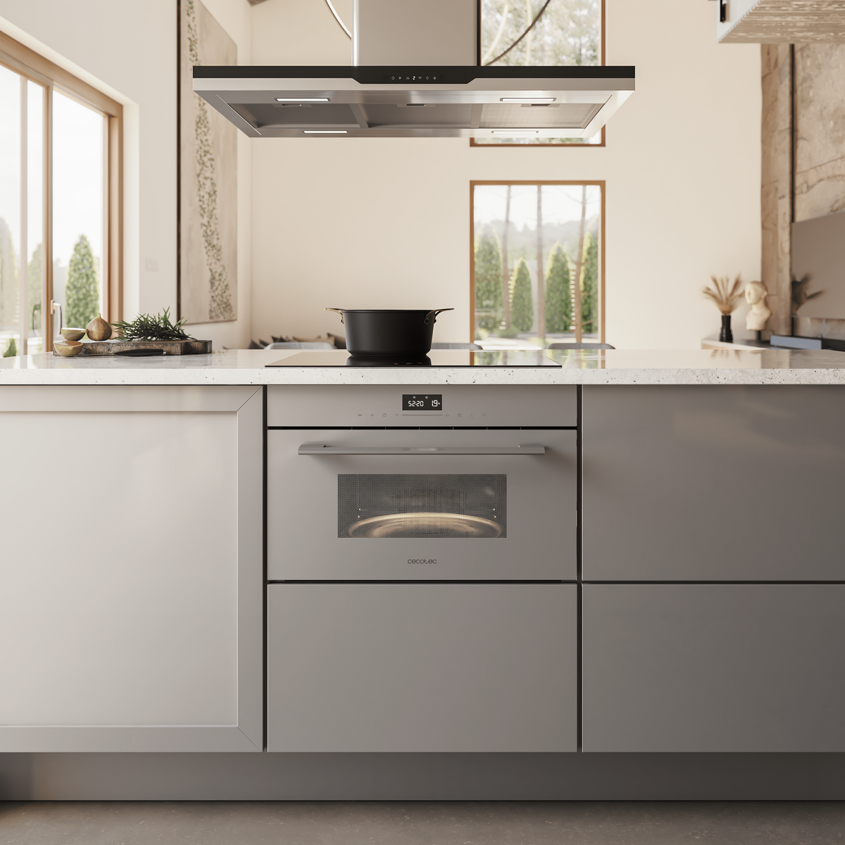 Una cocina moderna con una olla negra sobre una placa, un horno empotrado y una campana extractora. Ventanas muestran árboles.