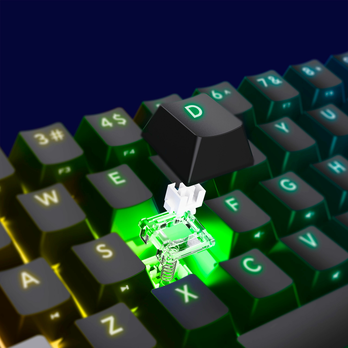 Zbliżenie klawiatury mechanicznej z usuniętym klawiszem, pokazujące przełącznik. Klawisz oznaczony 'D' jest podświetlony na zielono.