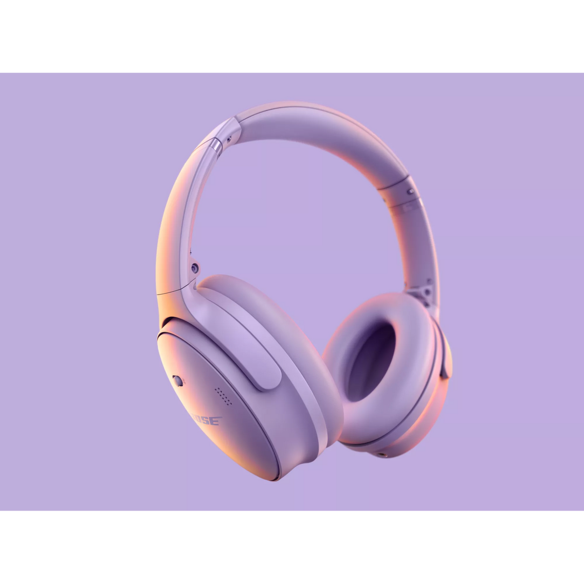 Para jasnofioletowych słuchawek marki Bose unosi się na jasnofioletowym tle, oświetlonym ciepłymi tonami.