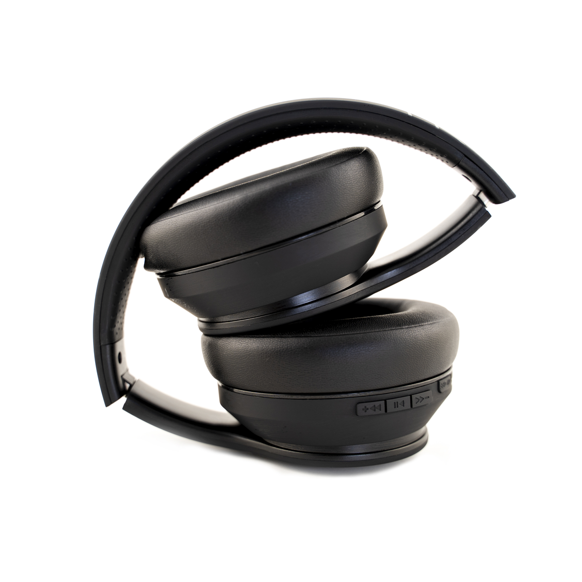 Auriculares negros y plegados sobre un fondo blanco. Los auriculares están apilados. Los botones son visibles en un auricular.