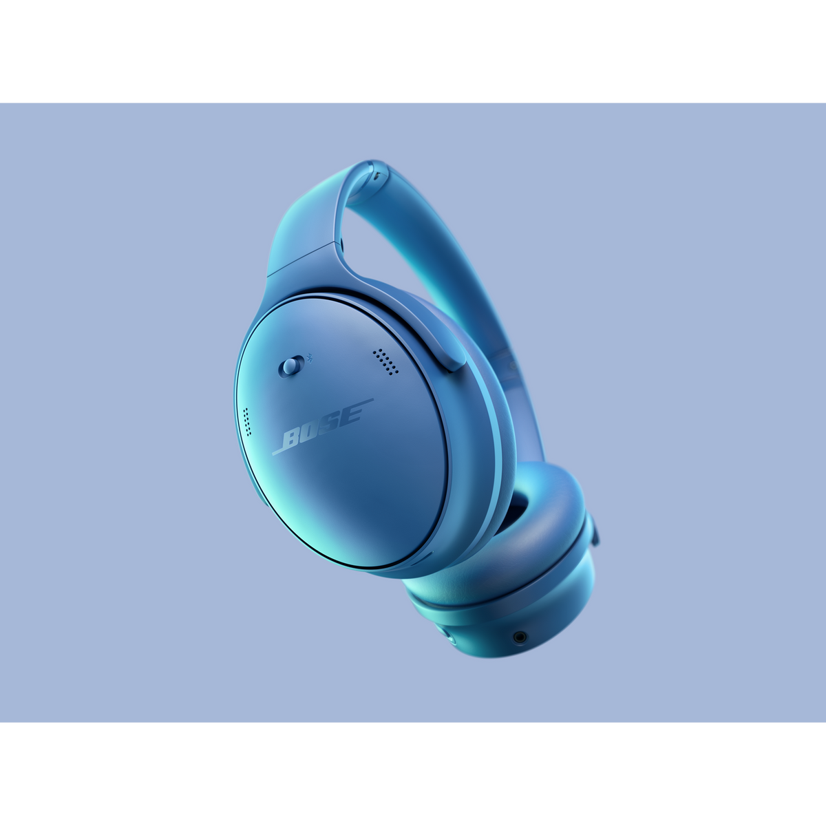 Niebieskie słuchawki Bose unoszące się w powietrzu. Słuchawki mają logo Bose. Tło to gradient niebieskiego i fioletowego.