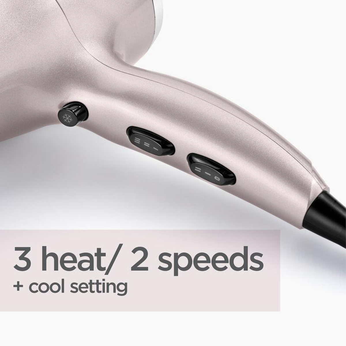 Close-up van een haardroger. Hij is lichtroze met zwarte knoppen. De tekst luidt "3 warmte/2 snelheden + koude stand".