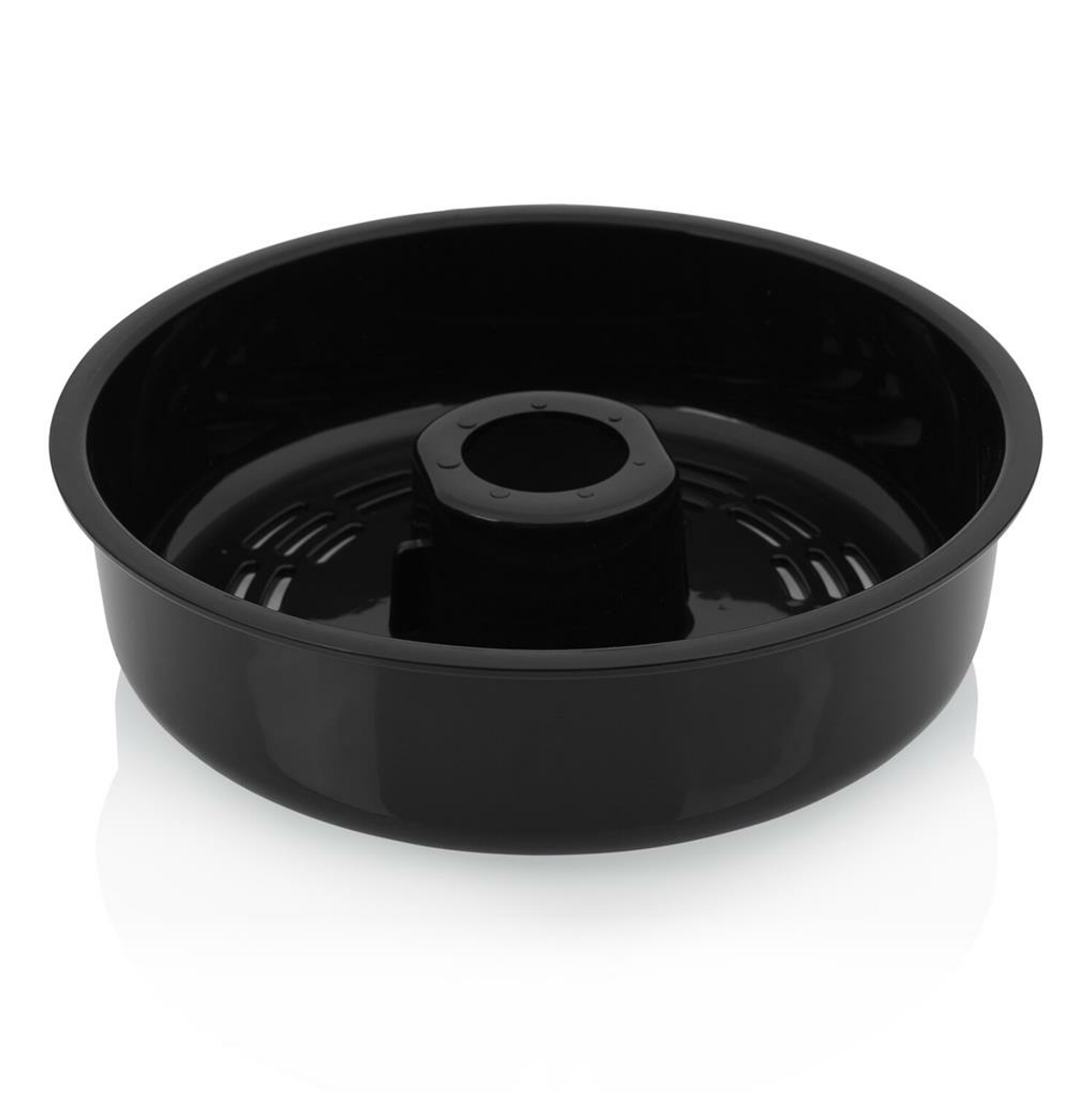 Una teglia nera per ciambella con un tubo centrale è centrata su una superficie bianca. La teglia è di forma rotonda ed è vuota.