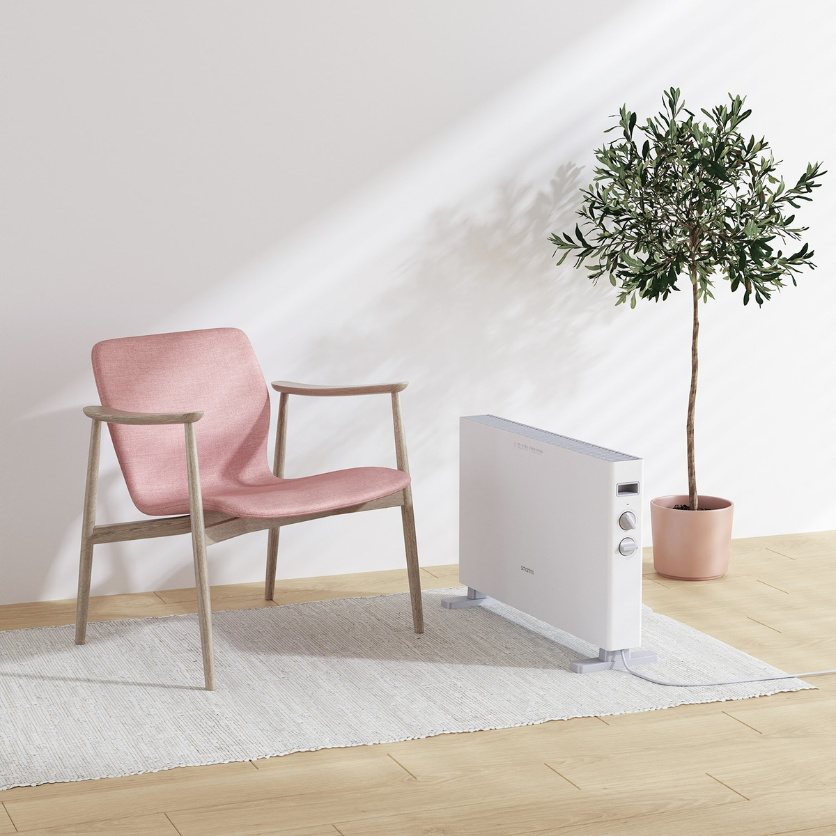 Una habitación con una silla rosa, un calentador blanco y un pequeño árbol en maceta. La habitación tiene pisos de madera y una alfombra blanca.
