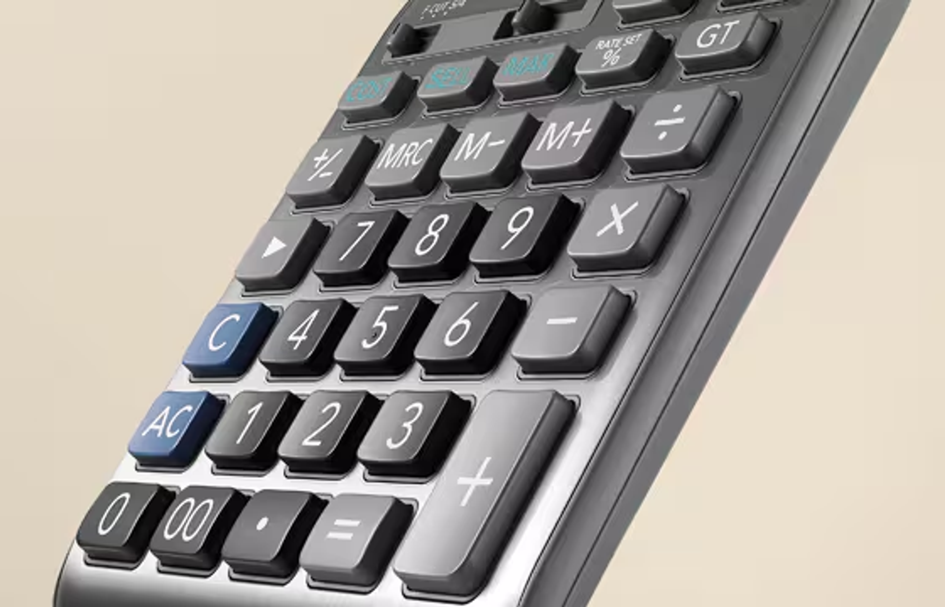 Zbliżenie kalkulatora z szarymi i czarnymi klawiszami. Widoczne liczby i symbole. Tło w jasnobeżowym kolorze.