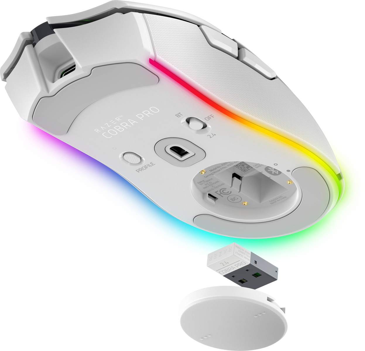 Biała mysz gamingowa Razer Cobra Pro z tęczowym paskiem świetlnym oraz odłączonym odbiornikiem USB i stacją ładującą na białym tle.